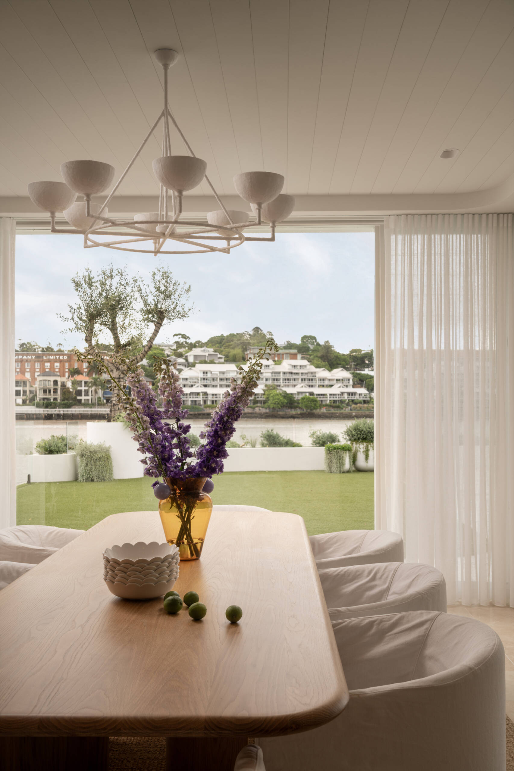 A serene dining area bridging the kitchen and outdoor spaces with warm textures and relaxed elegance.