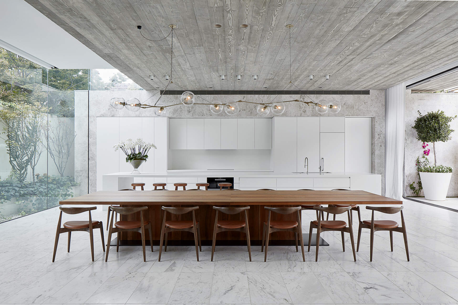 An expansive open plan living space connects kitchen, dining and lounge areas with seamless indoor outdoor flow.