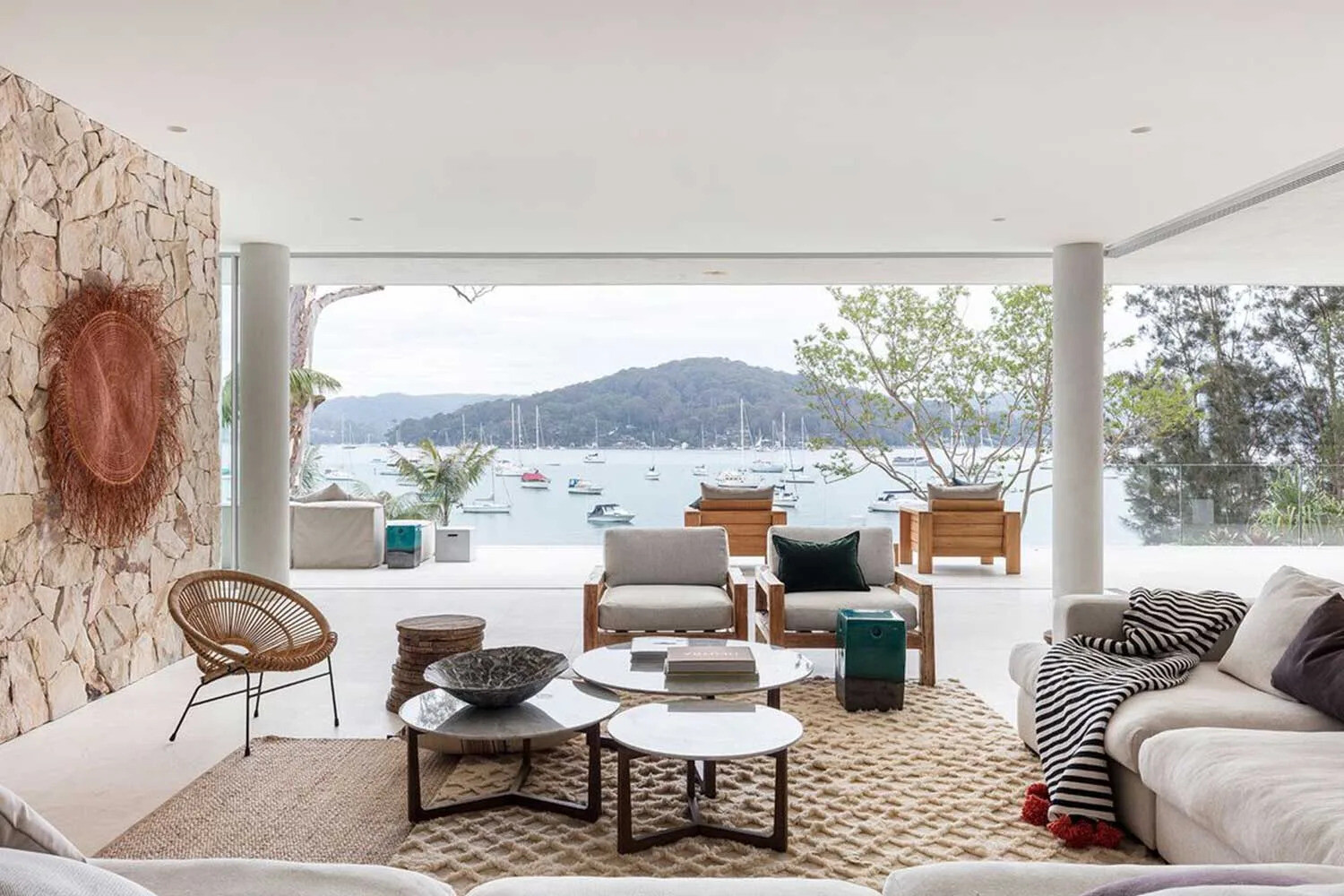 Casual living area with lounge, dining and bar spaces positioned closer to the water for relaxed, informal entertaining.