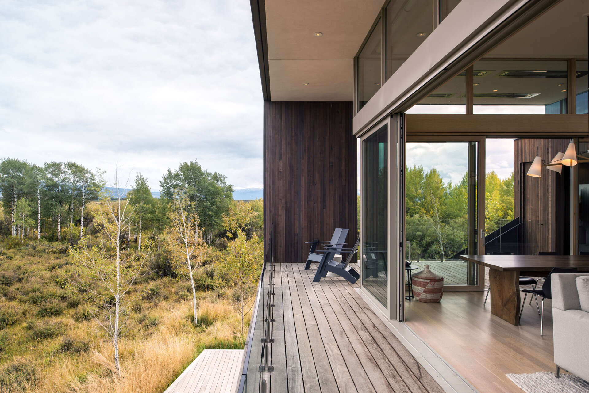 An elevated living space opens to a wrap around balcony overlooking wetlands and mountain views.