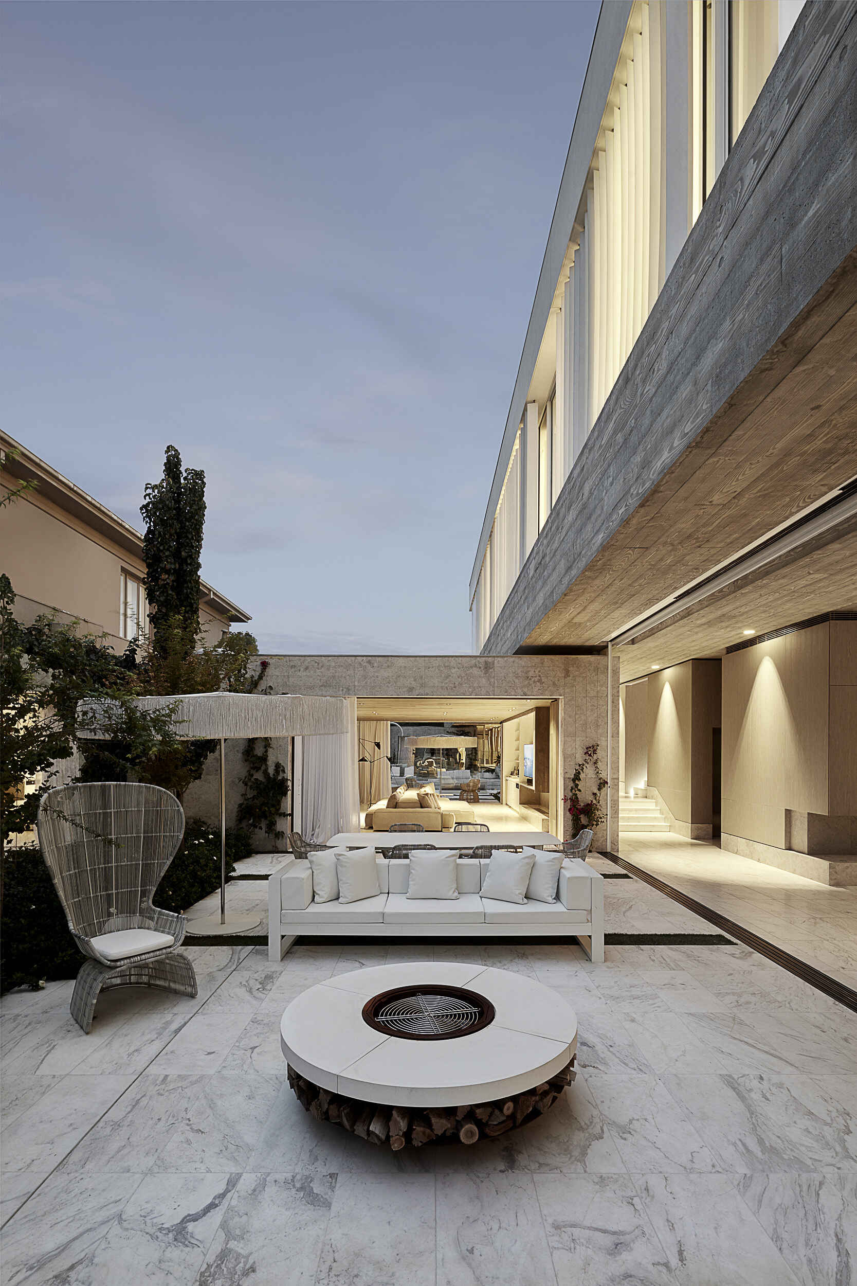 An outdoor lounge with a freestanding fire pit adds warmth and atmosphere to the home’s exterior spaces.