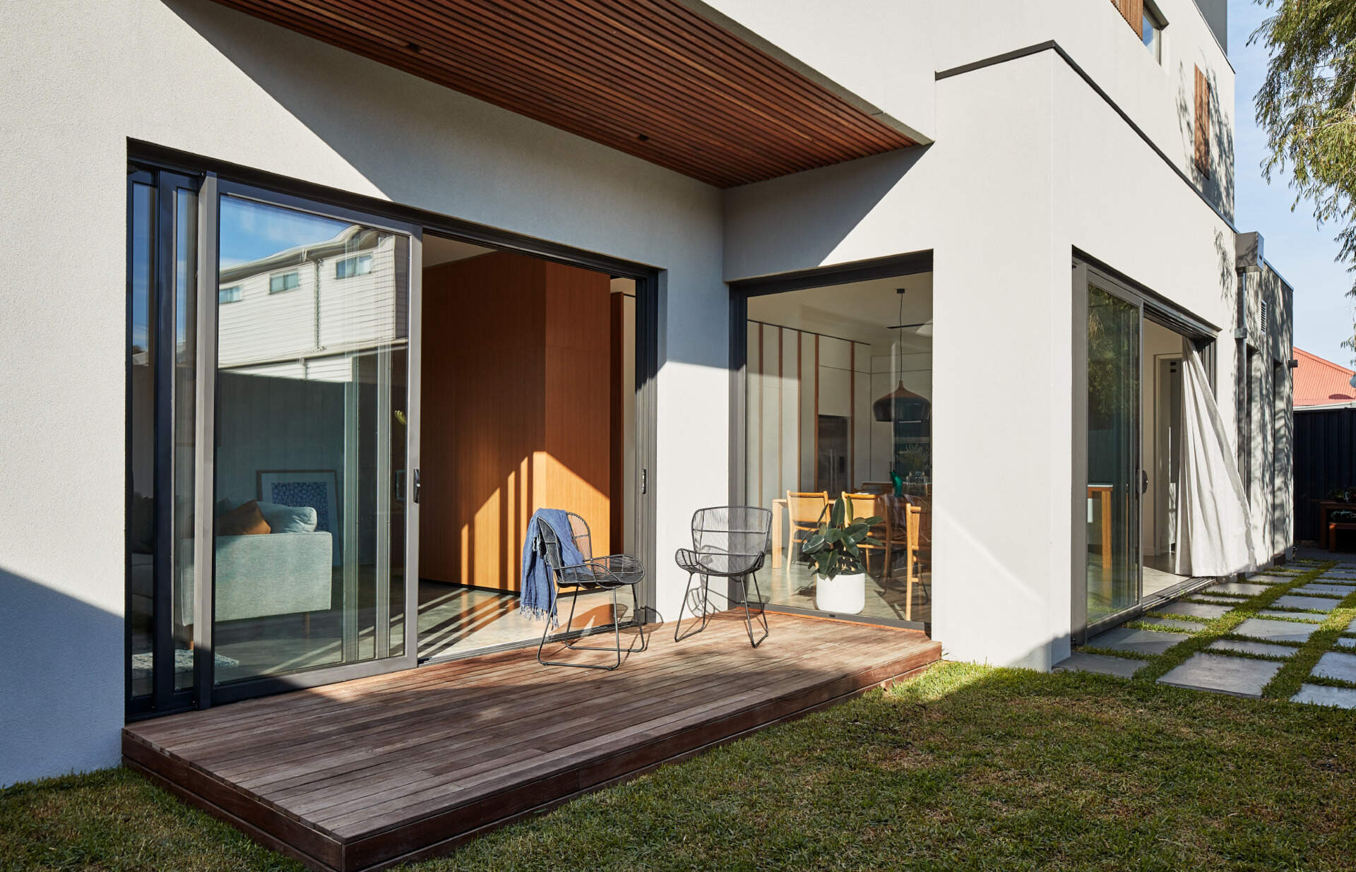 Sliding glass doors connect the living room to a deck and backyard, blurring the line between inside and out.