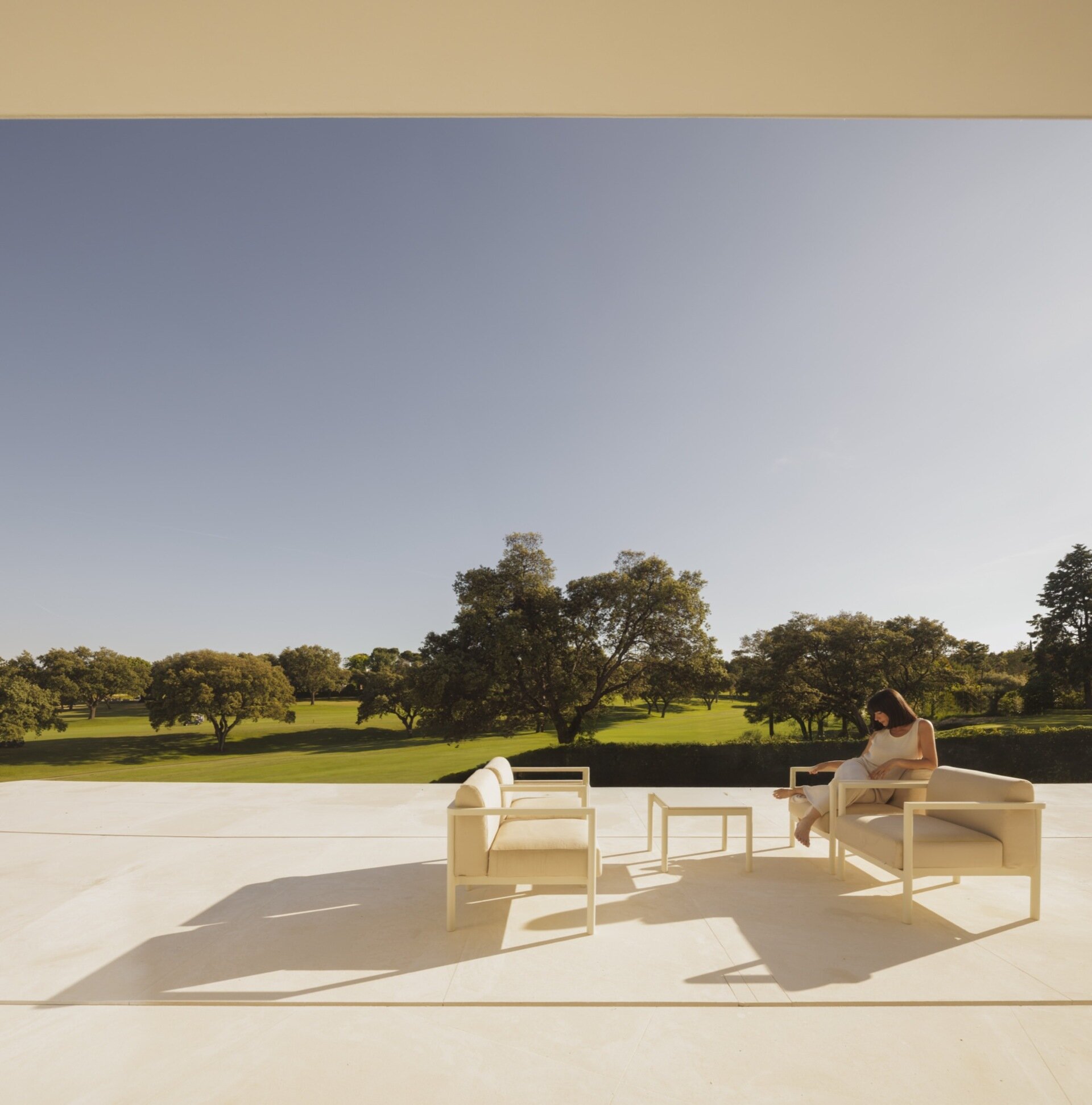 A minimalist home has a variety of patio areas and a shaded terrace.
