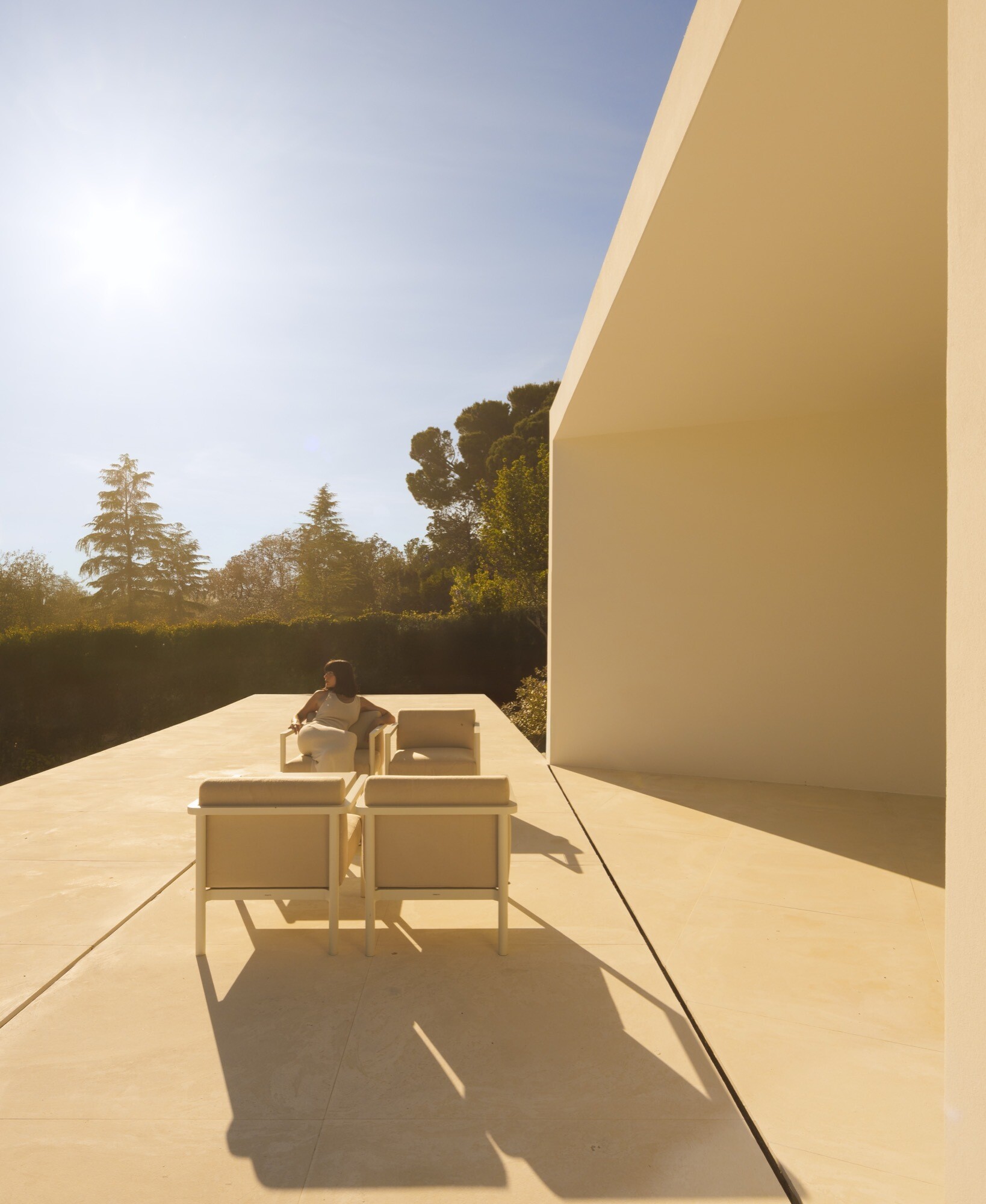 A minimalist home has a variety of patio areas and a shaded terrace.