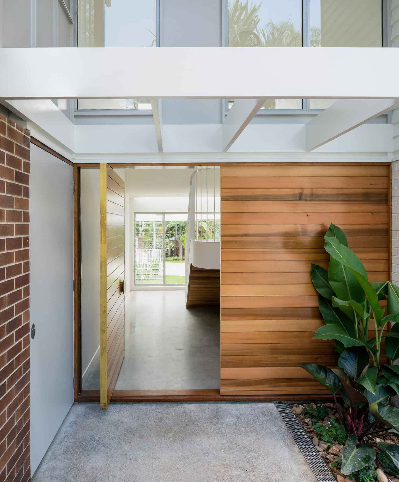 A pivoting timber front door and a clear view to the courtyard set the tone for this light-filled home.