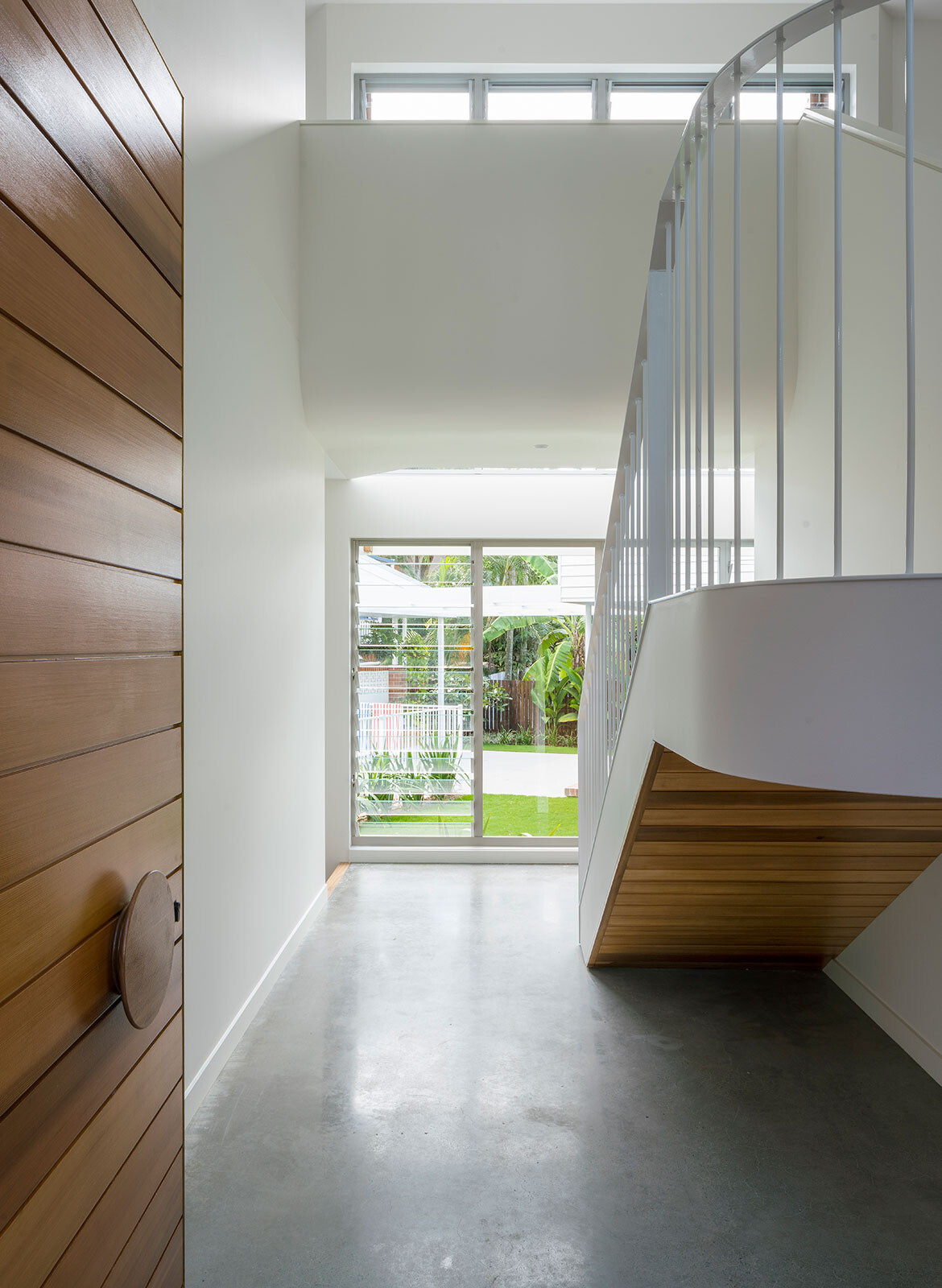 A pivoting timber front door and a clear view to the courtyard set the tone for this light-filled home.
