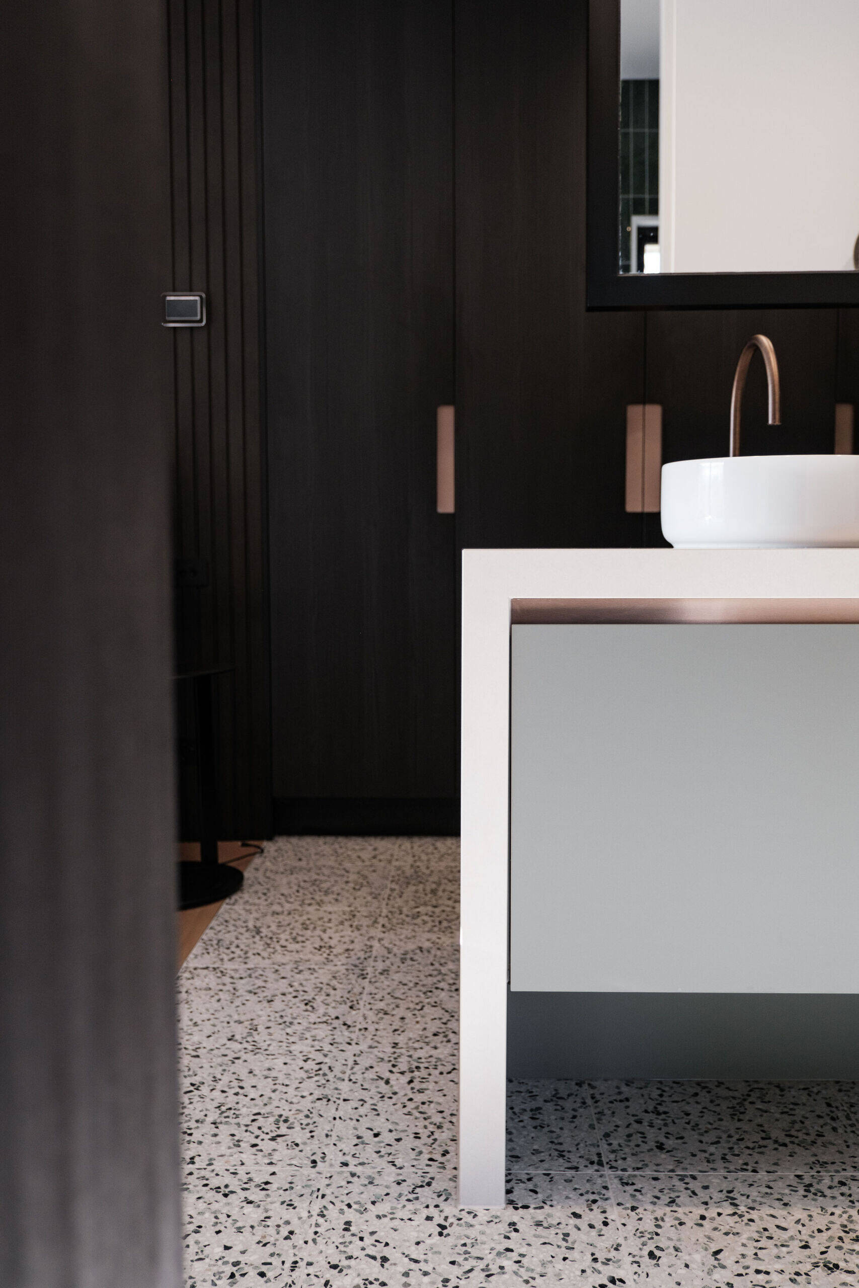 A sculptural bathroom with emerald tiles, terrazzo floors and floating mirrors designed for an elevated daily experience.