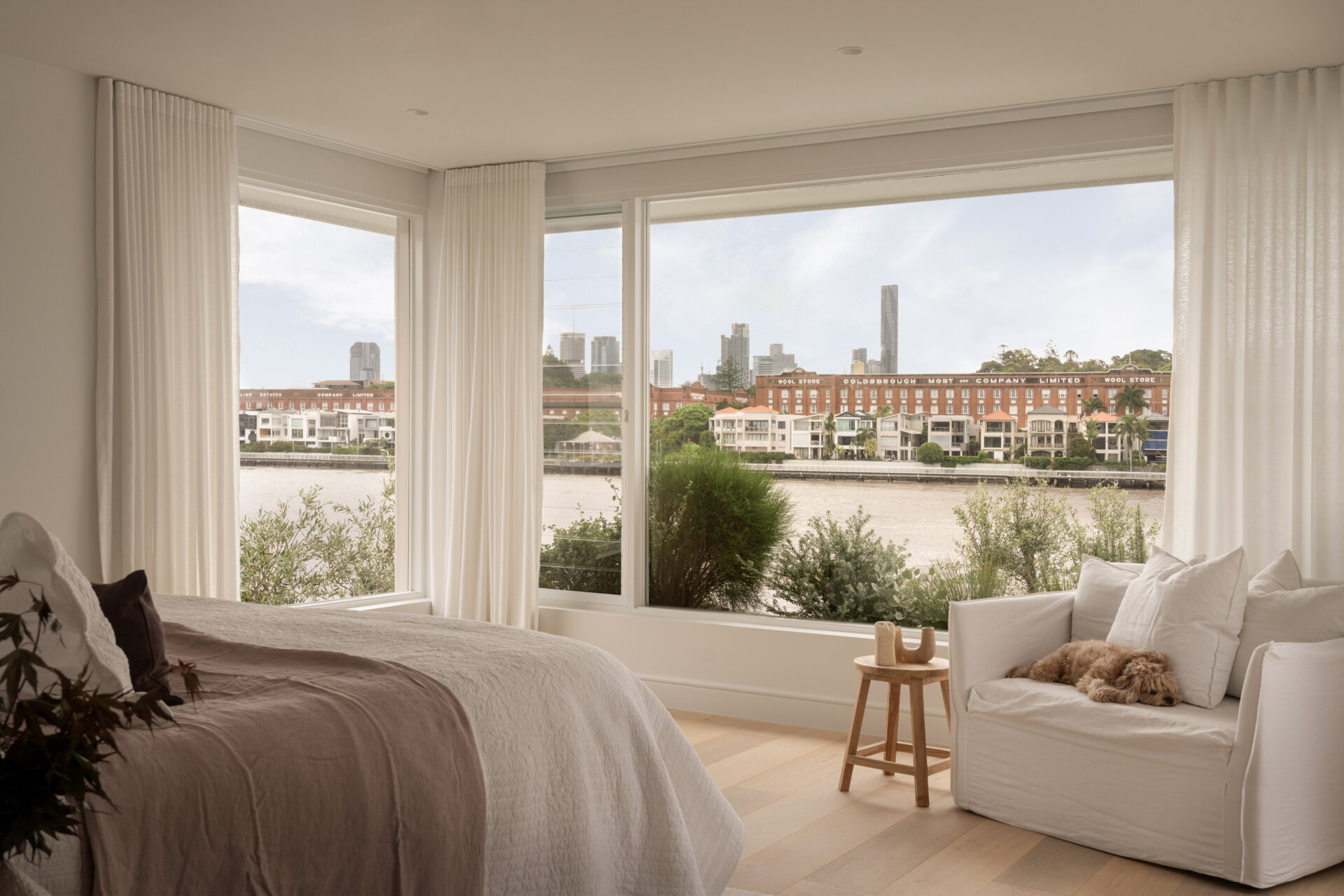 The primary suite is designed for unwinding. The bedroom stays understated and layered, with a calm presence that settles instantly. In the walk-in robe, a clean white scheme comes to life with warm lighting bouncing off subtle timber grain.