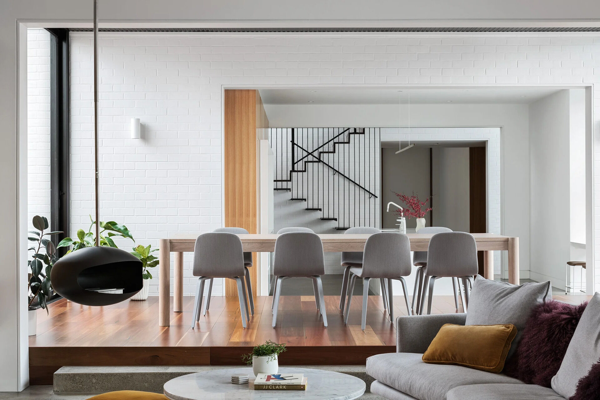 A dining area that opens to the garden with sliding doors, timber decking, and versatile outdoor steps.