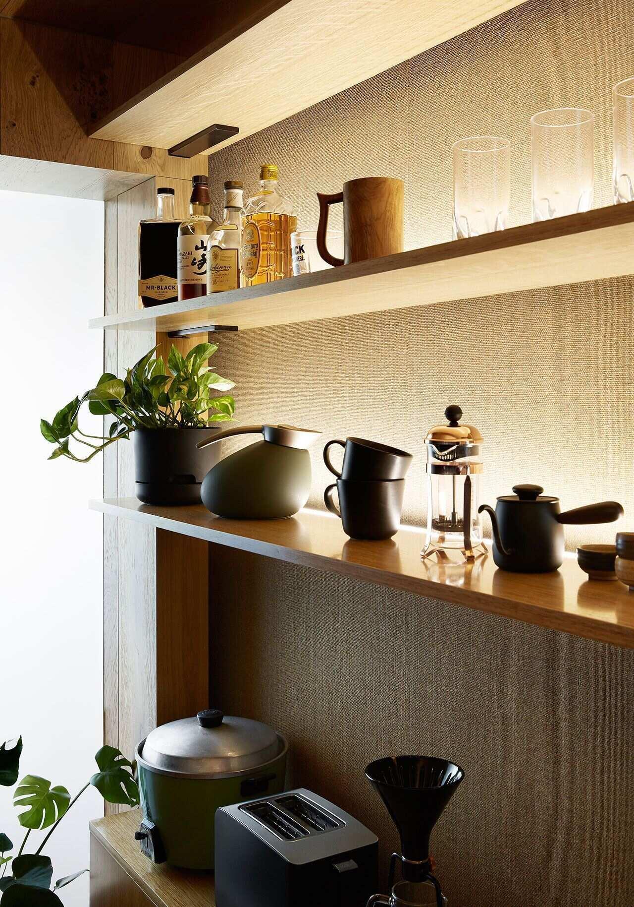 Open shelves with hidden lighting and dedicated storage give this small kitchen both personality and practicality.