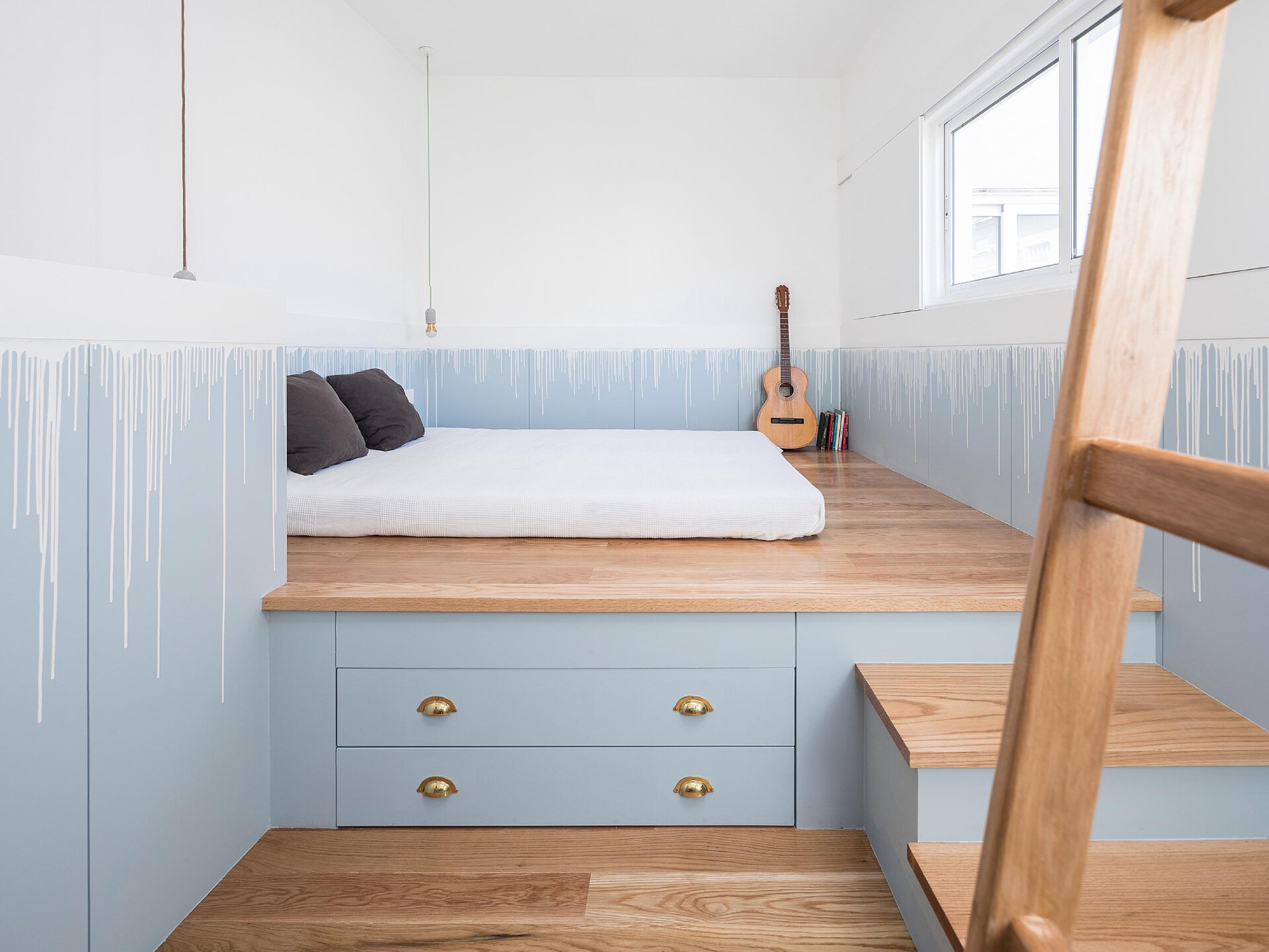 A thoughtfully renovated tiny house hidden behind a modernist building, has a pink exterior and soft blue interior.