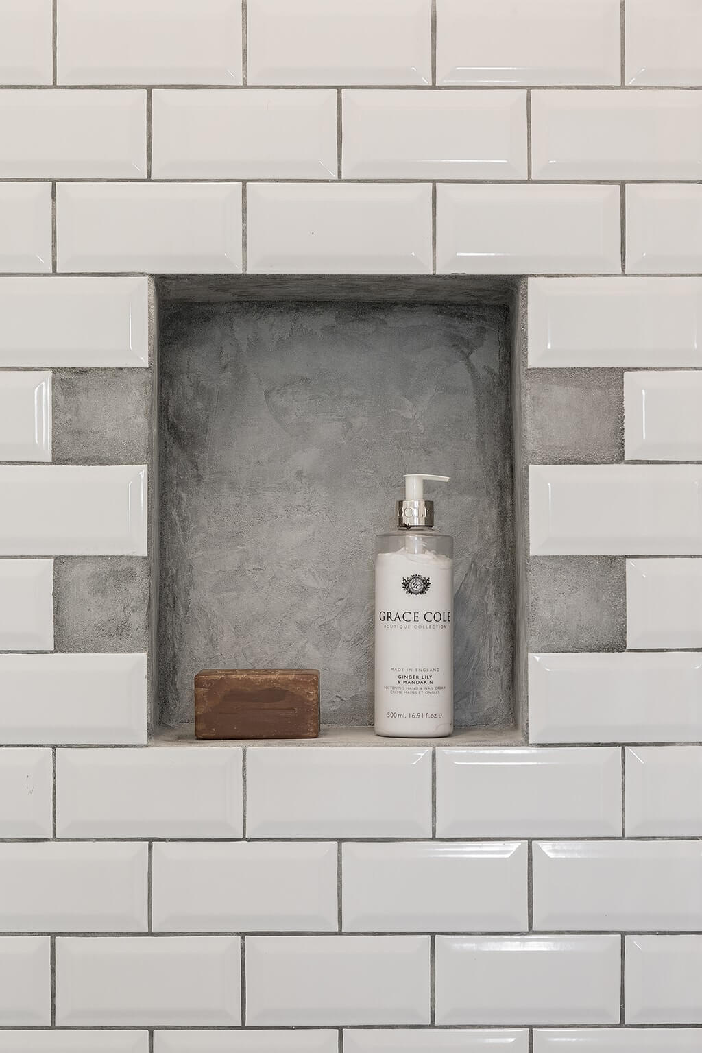 A tiny house bathroom in Porto featuring white subway tiles, a built-in shower shelf, and a corner basin that maximizes space without sacrificing style.
