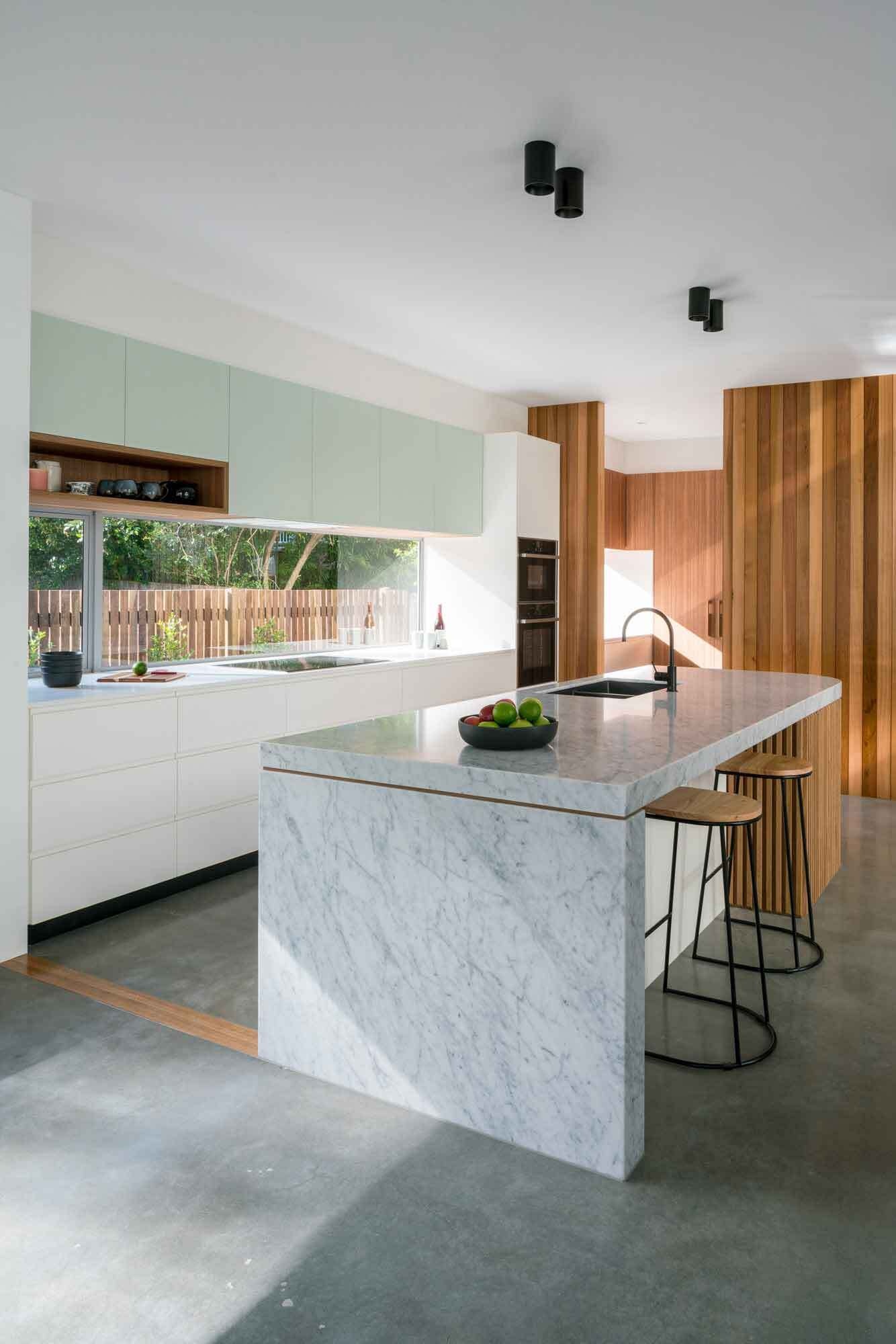 Clean cabinetry and a curved kitchen island create a calm, modern kitchen with mid-century influence.