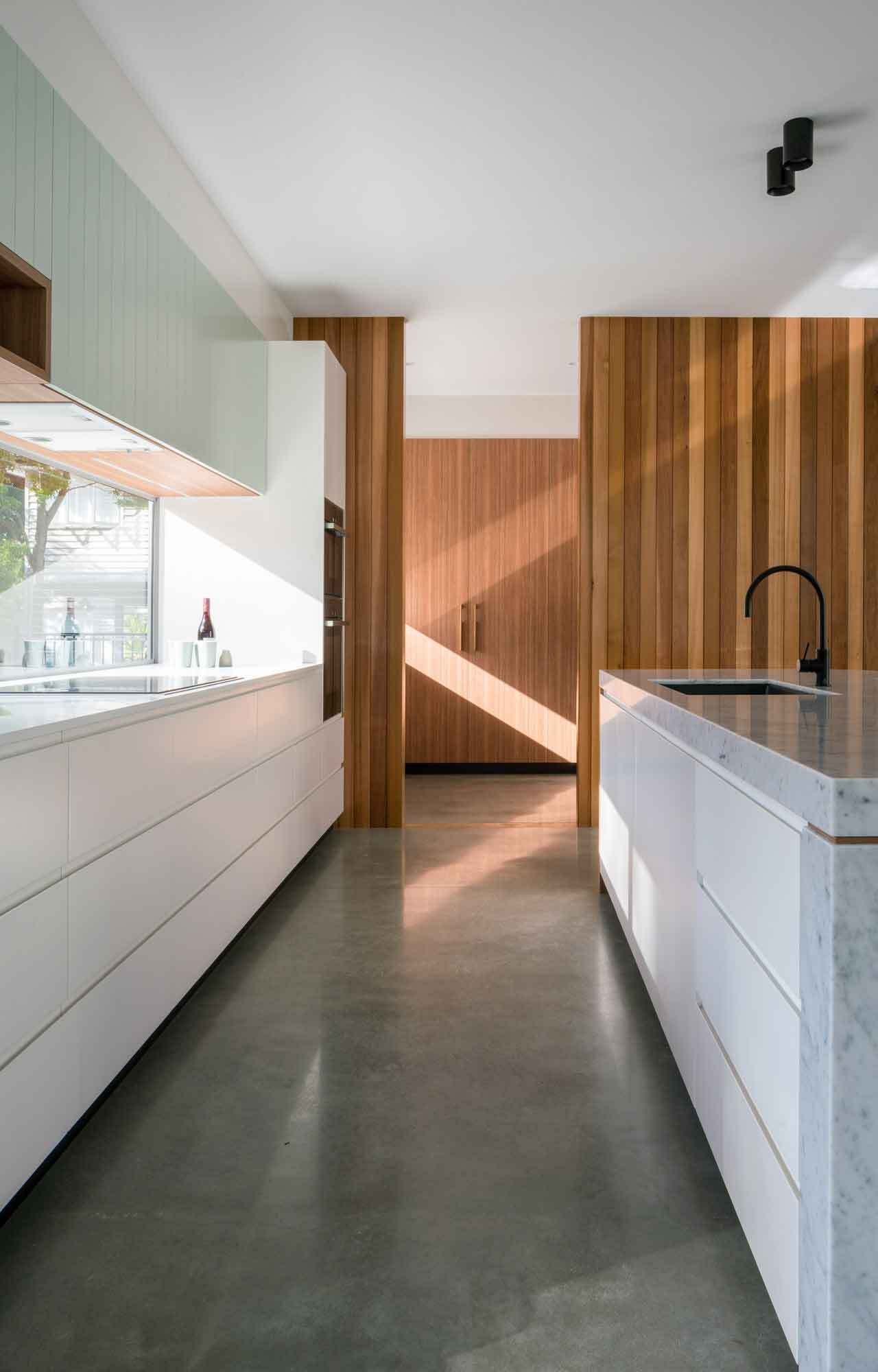 Clean cabinetry and a curved kitchen island create a calm, modern kitchen with mid-century influence.