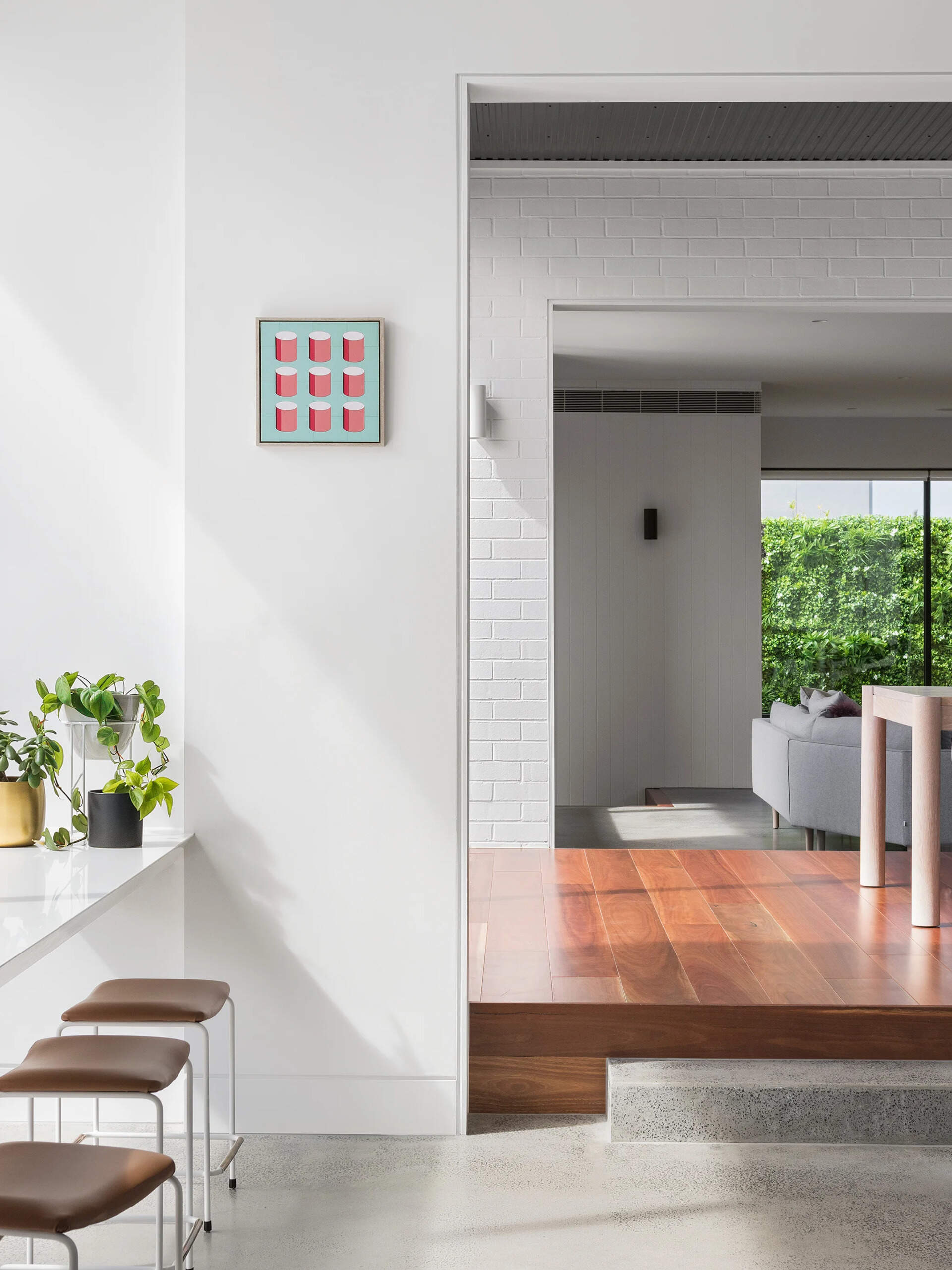 A modern kitchen with a white island, window-side seating, and hidden appliances blends function and style effortlessly.