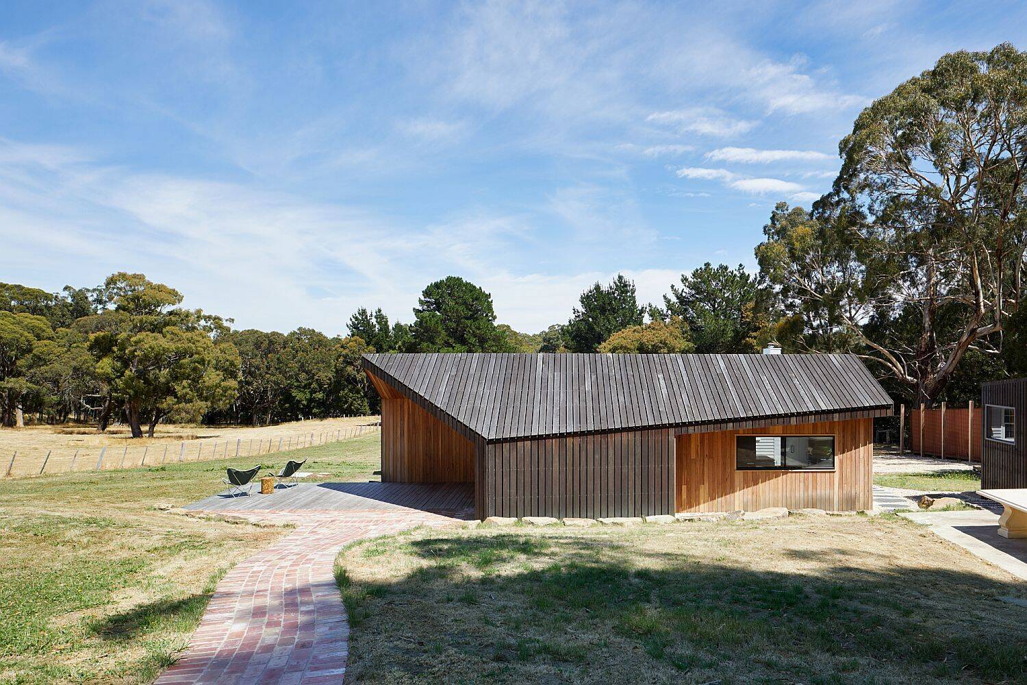 Black stained spotted gum cladding gives this new addition a rustic character inspired by the look of historic farm buildings.