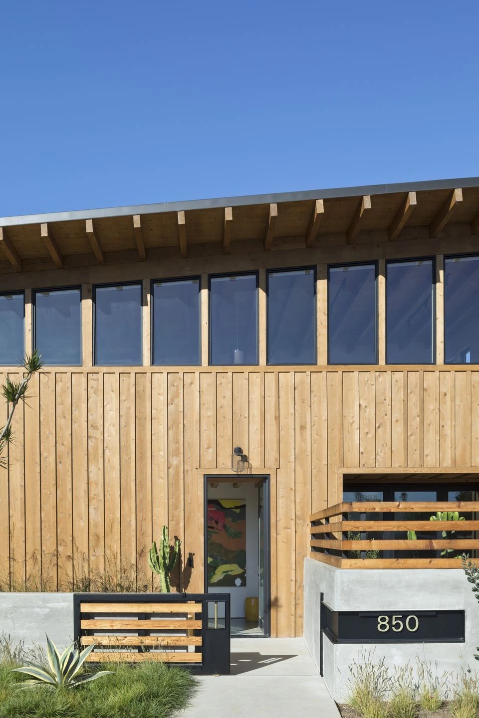 A custom gate, concrete walls, and water feature create a quiet buffer between the Cornish House and the busy street.