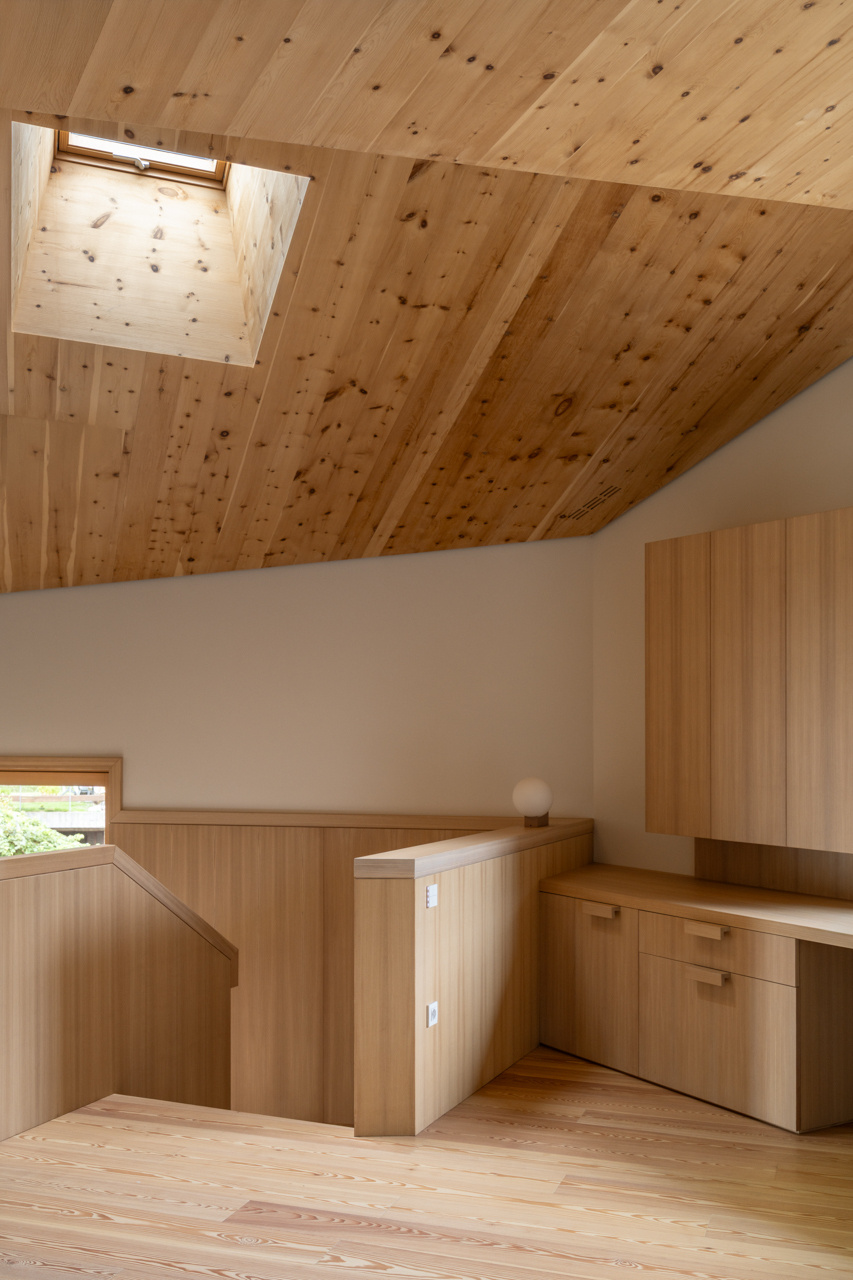 A wood clad stair and built in desk define an upper level study filled with light and cedarwood warmth.
