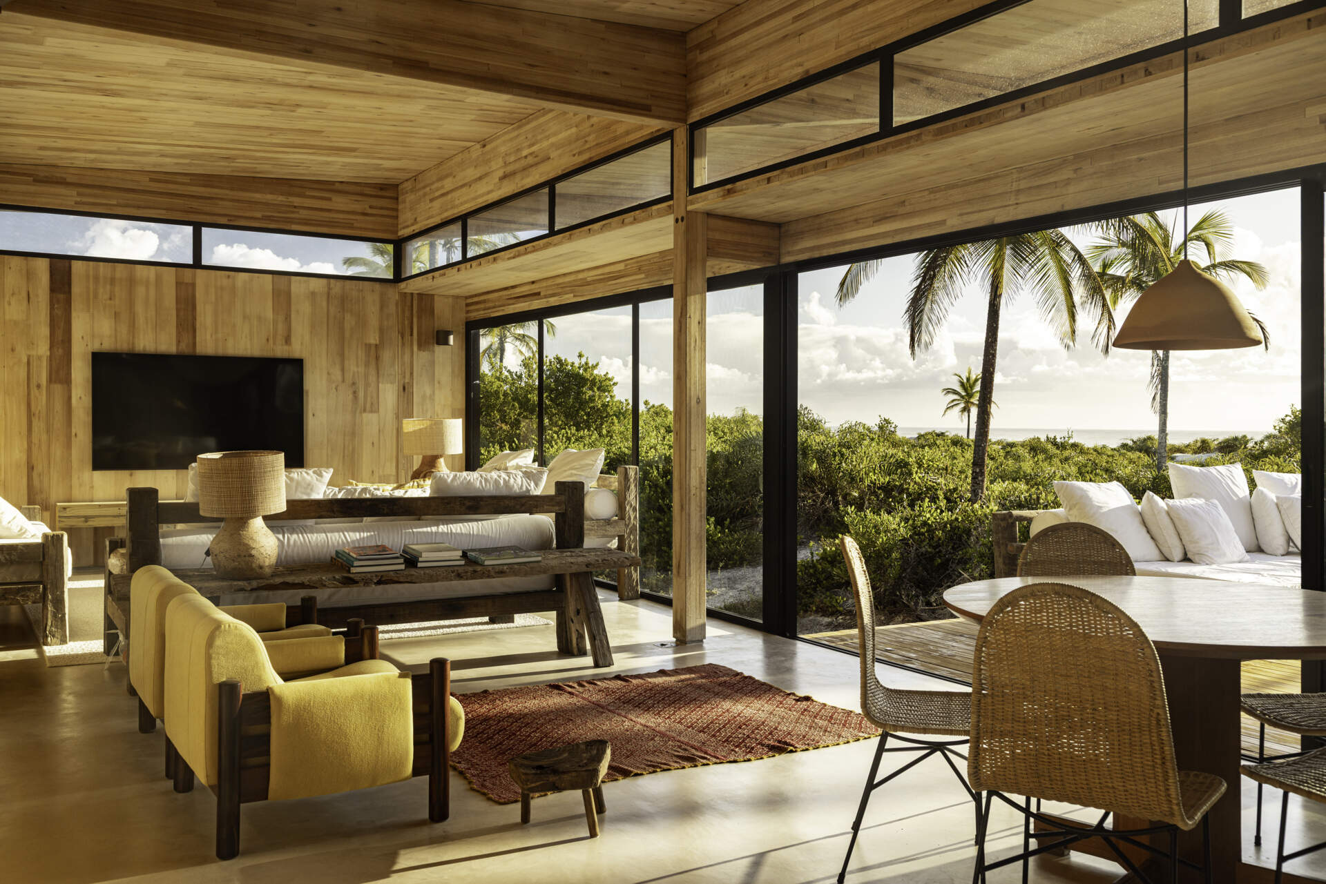 A modular home set between the river and the sea, designed for calm tropical living. Warm wood interiors, large glass openings, and open patios create a seamless flow between forest, coast, and indoor comfort.