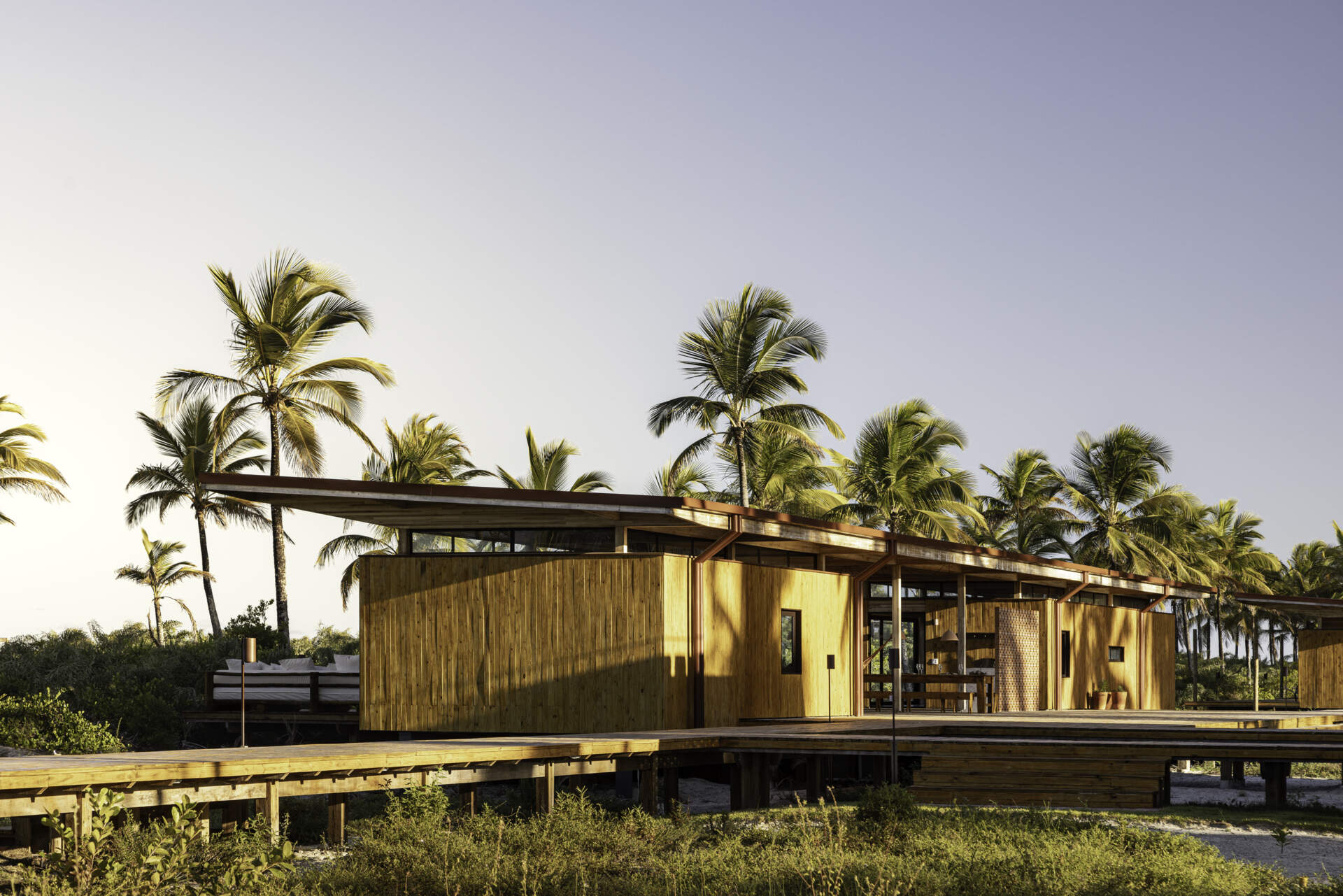 A modular home set between the river and the sea, designed for calm tropical living. Warm wood interiors, large glass openings, and open patios create a seamless flow between forest, coast, and indoor comfort.
