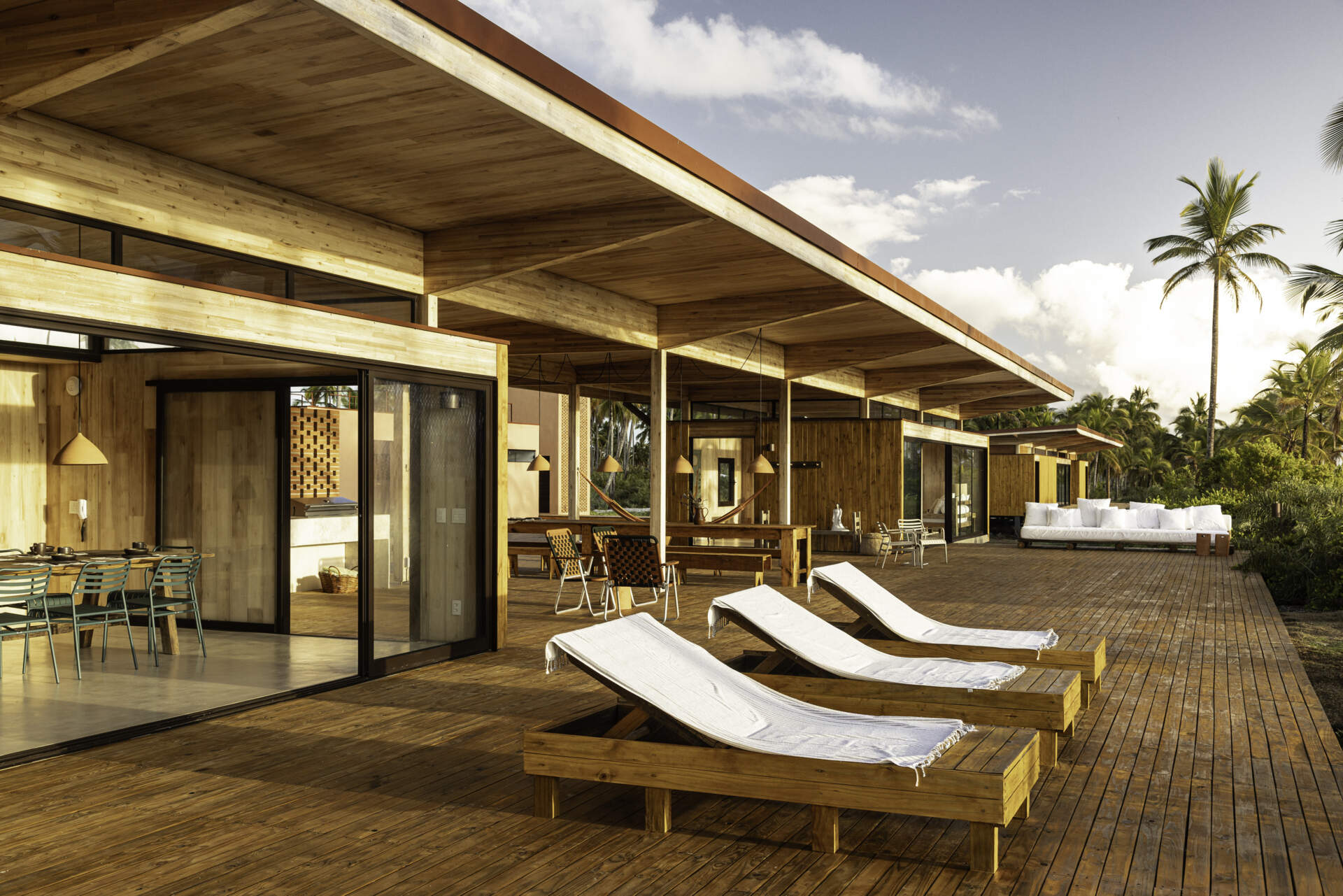 A modular home set between the river and the sea, designed for calm tropical living. Warm wood interiors, large glass openings, and open patios create a seamless flow between forest, coast, and indoor comfort.