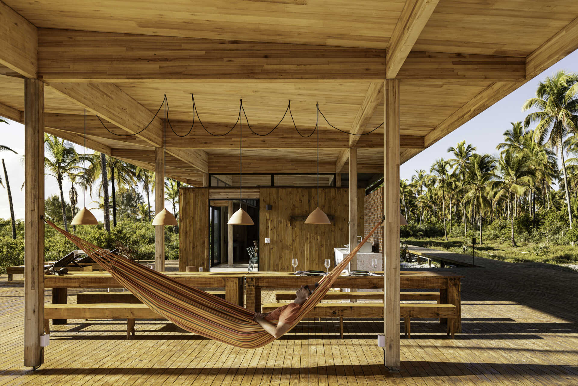 A modular home set between the river and the sea, designed for calm tropical living. Warm wood interiors, large glass openings, and open patios create a seamless flow between forest, coast, and indoor comfort.