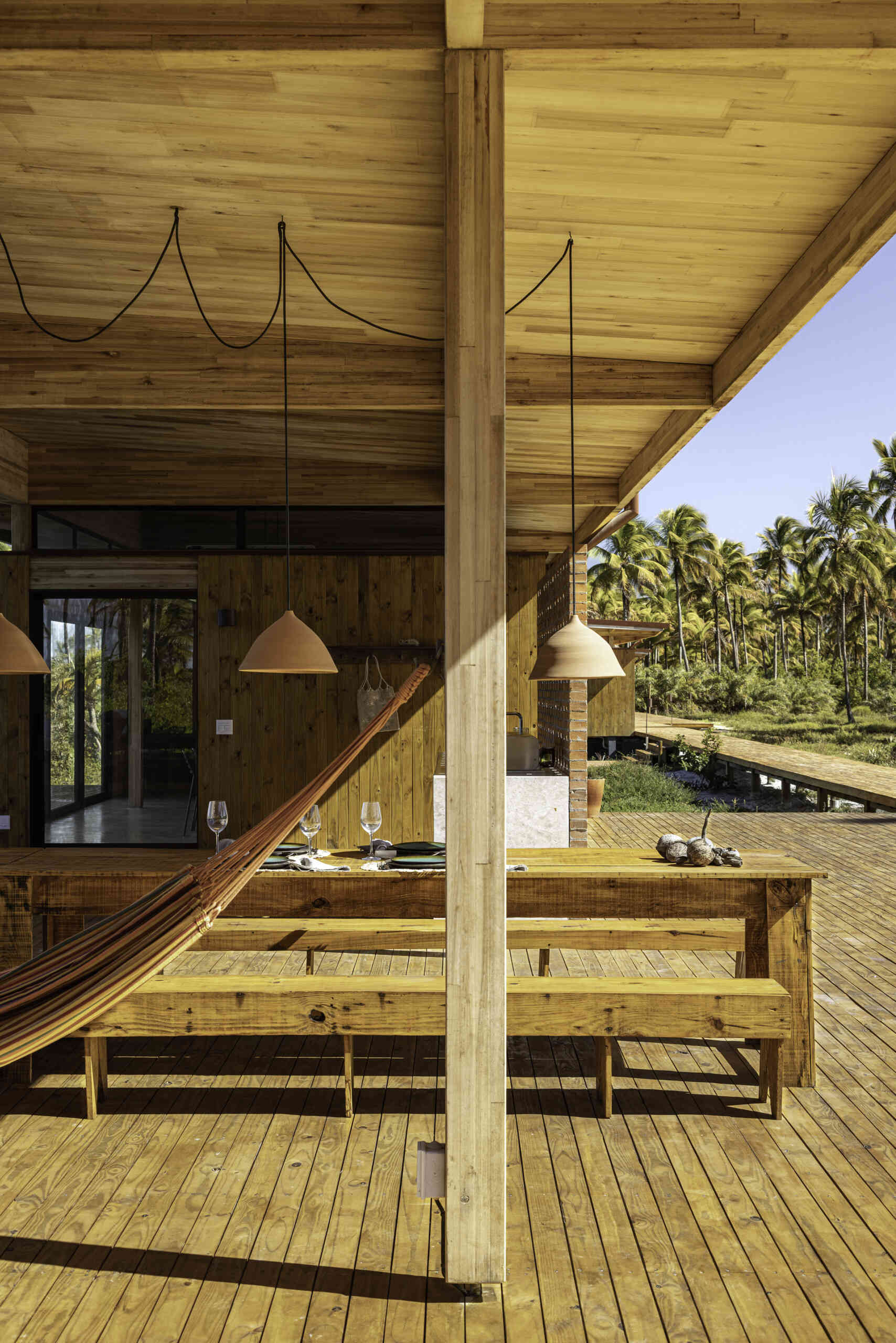 A modular home set between the river and the sea, designed for calm tropical living. Warm wood interiors, large glass openings, and open patios create a seamless flow between forest, coast, and indoor comfort.