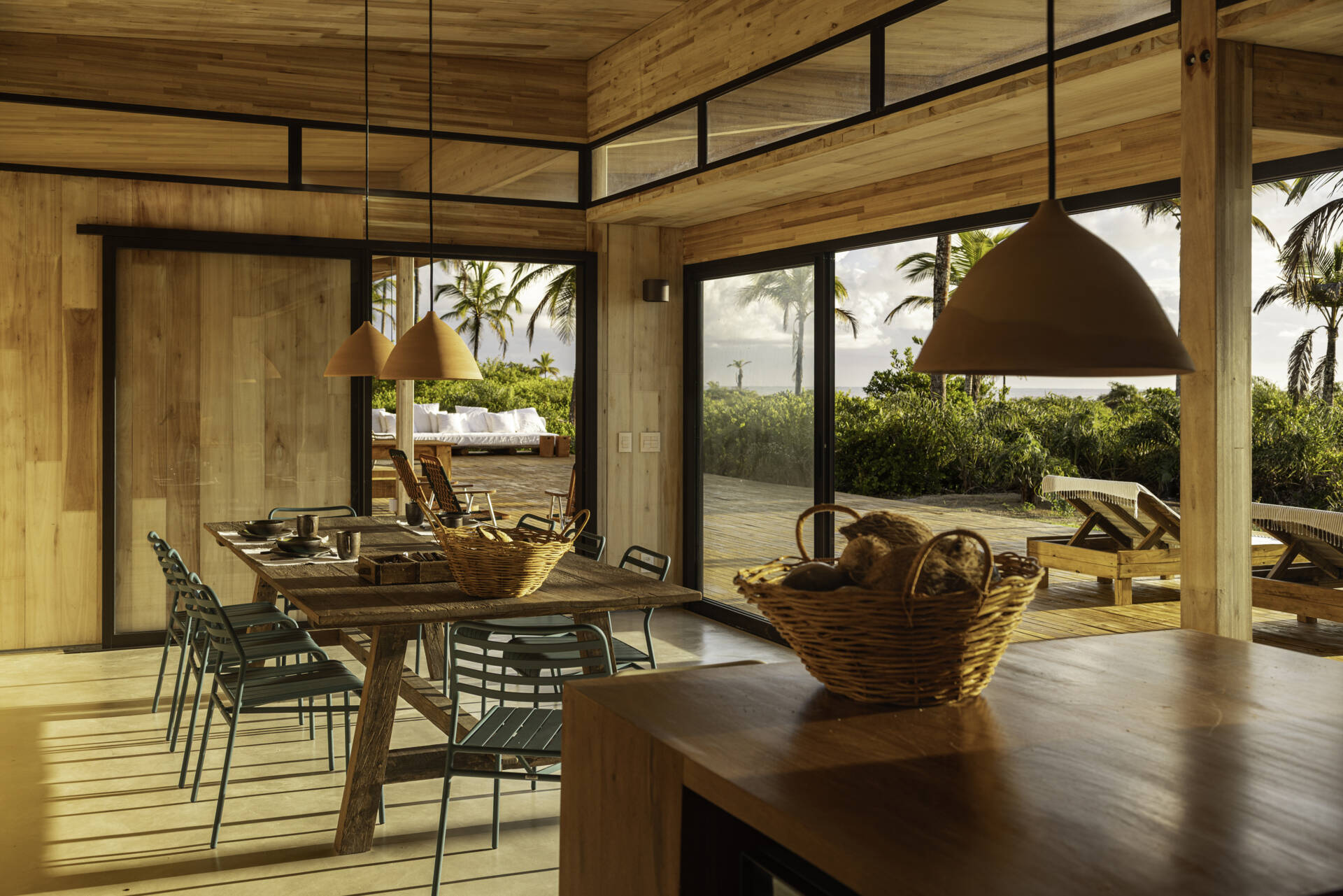 A modular home set between the river and the sea, designed for calm tropical living. Warm wood interiors, large glass openings, and open patios create a seamless flow between forest, coast, and indoor comfort.