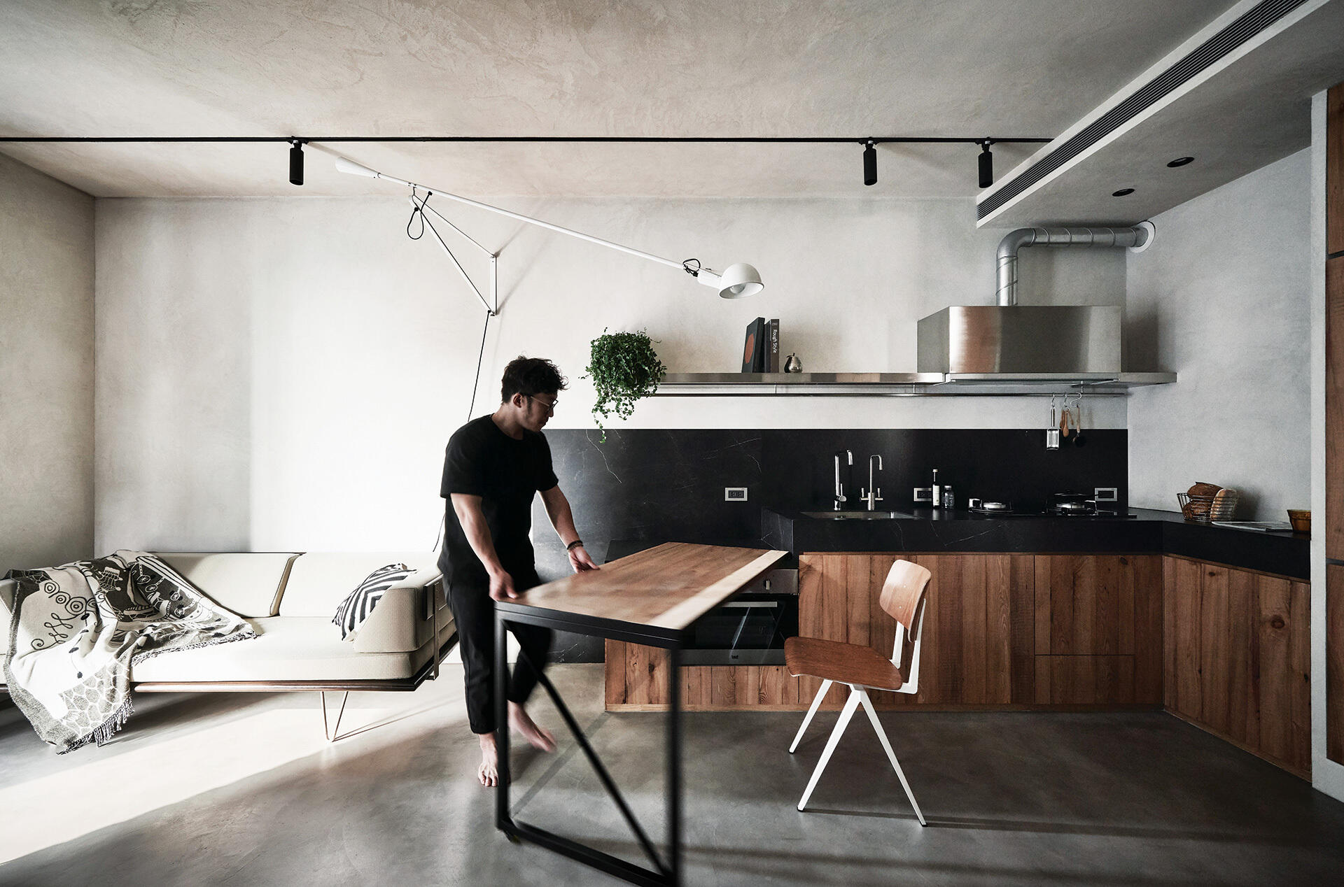 Open plan living in a small apartment with a movable kitchen counter that doubles as a dining table, maximizing space.