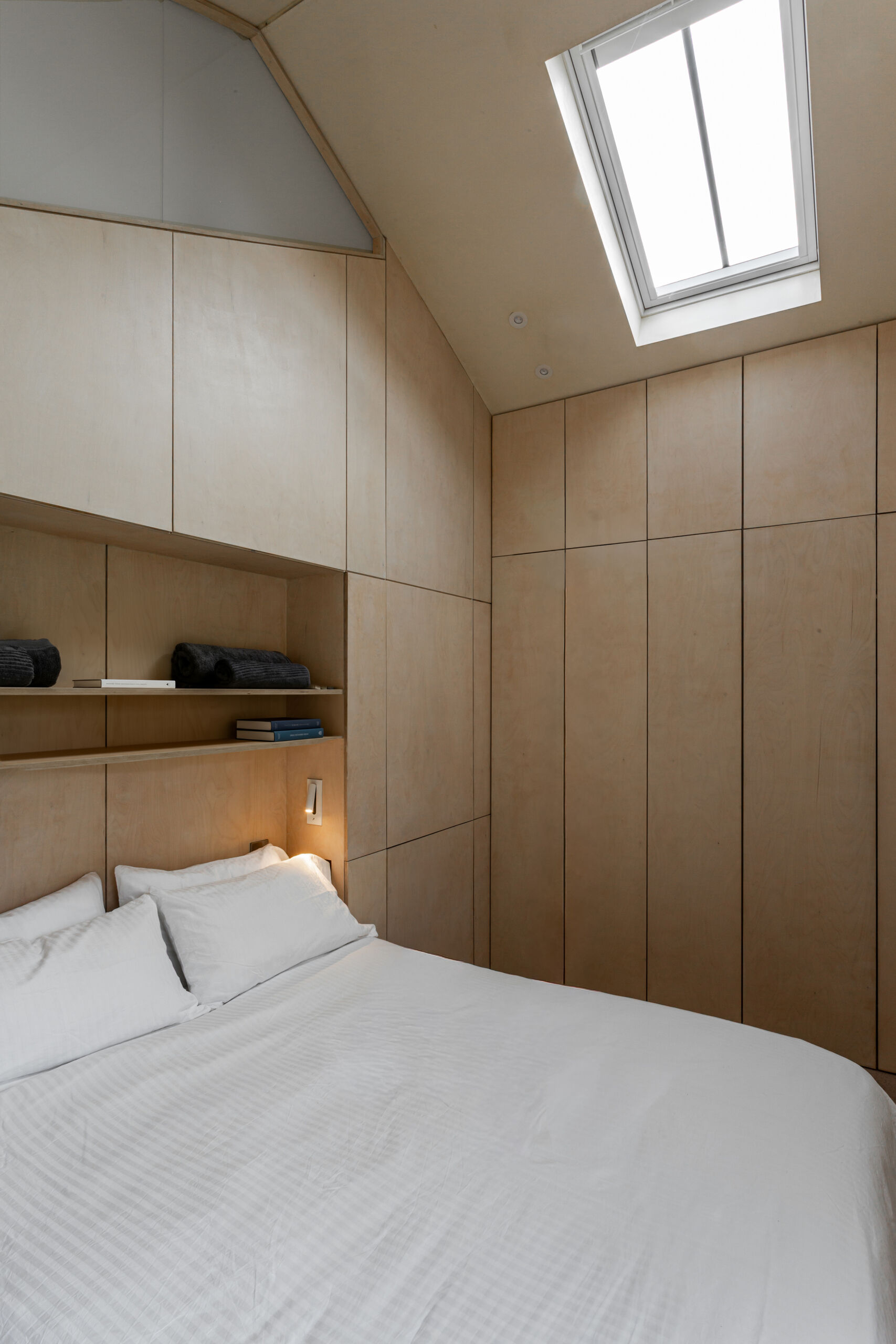 El dormitorio principal se encuentra dentro de la estructura de piedra restaurada. La profunda revelación crea un suave nicho para sentarse y reflexionar, y enmarca perfectamente las vistas al jardín.