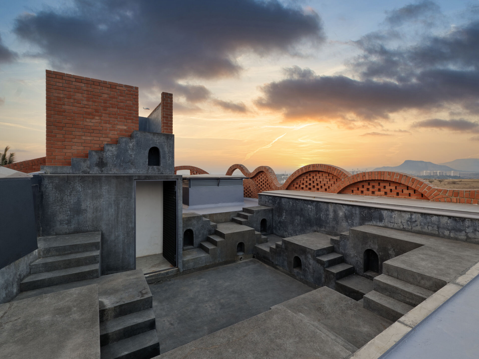 The rooftop of a home in India that features different levels and stairs connecting them.