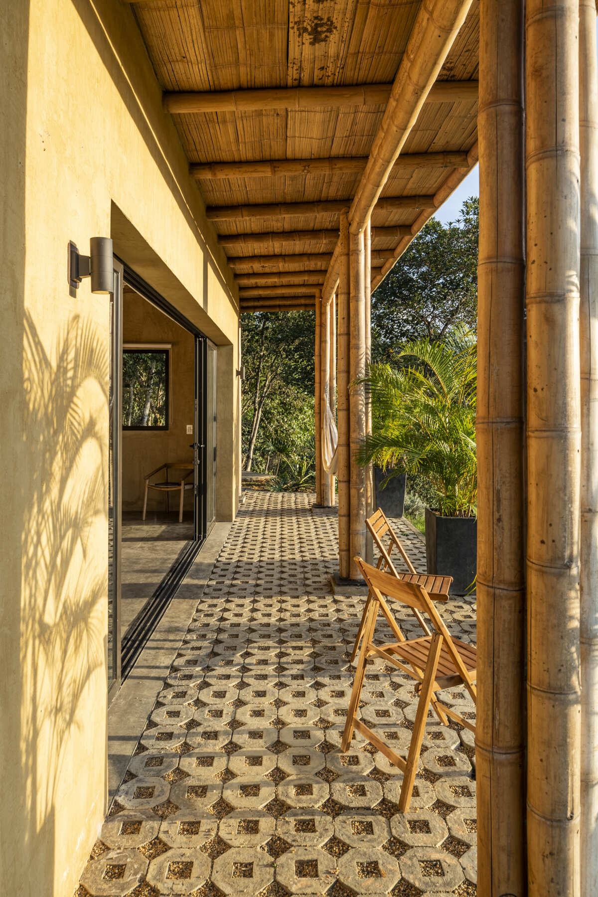This Colombian home reimagines rural architecture with a butterfly roof that collects rainwater, bamboo-and-steel structural details, and an open interior where the bedroom, kitchenette, and a hidden curved-wall bathroom blend seamlessly, creating a sustainable, modern, and deeply connected living experience.