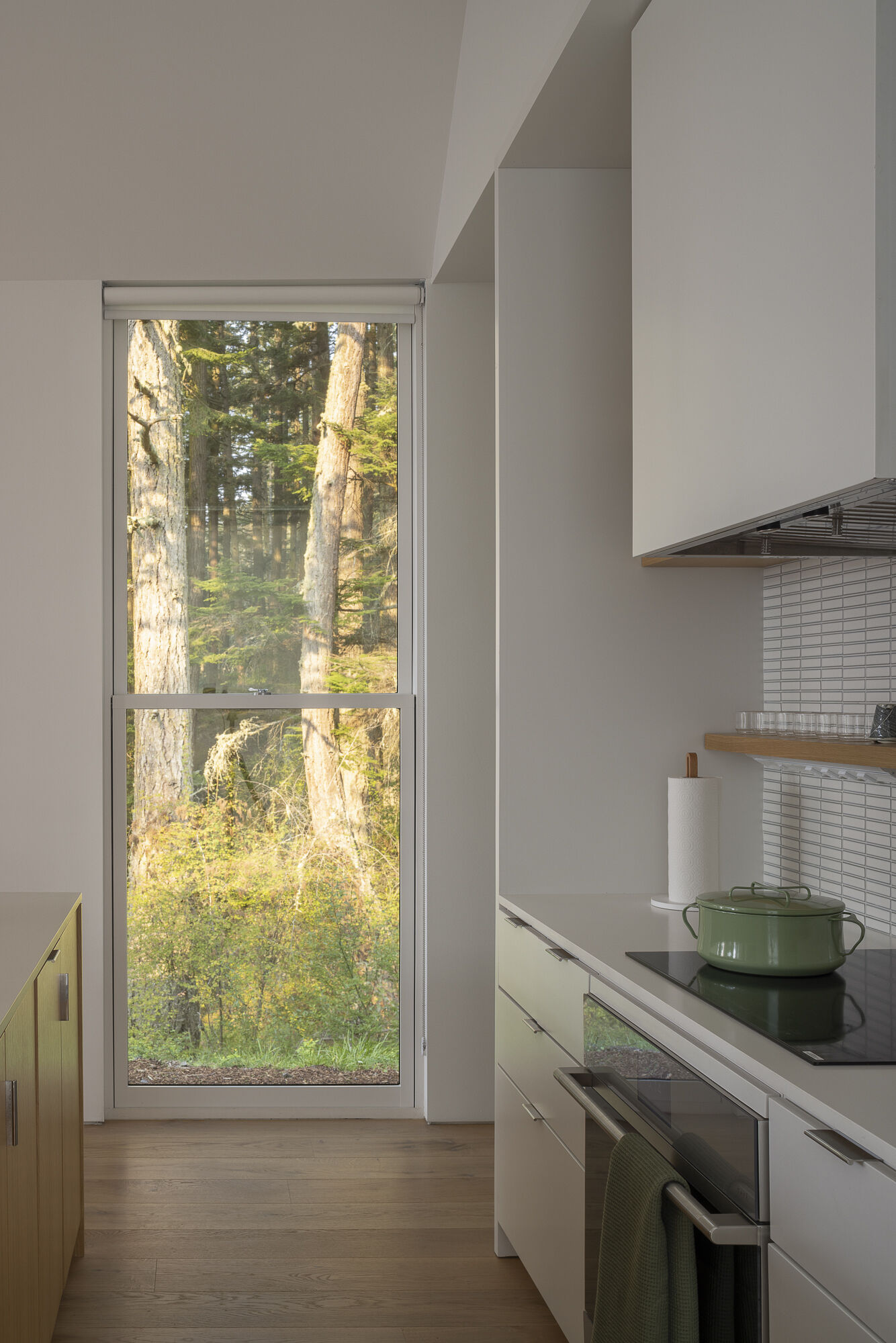 A restrained palette in the dining and kitchen spaces allows light, landscape, and artwork to take center stage.