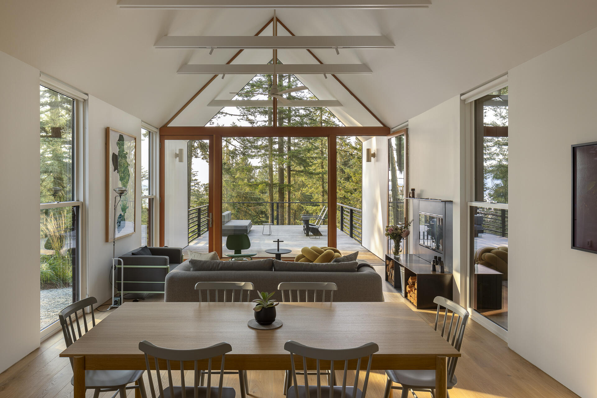 Tall volumes and full height glazing bring light and forest filtered views into this compact yet expansive living space.