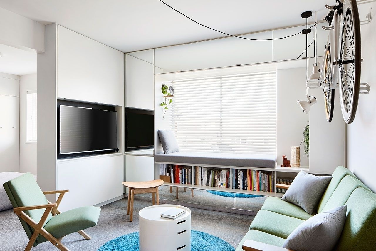 Hidden behind cabinetry, this living room doubles as a home office, allowing work tools to disappear completely when not in use.