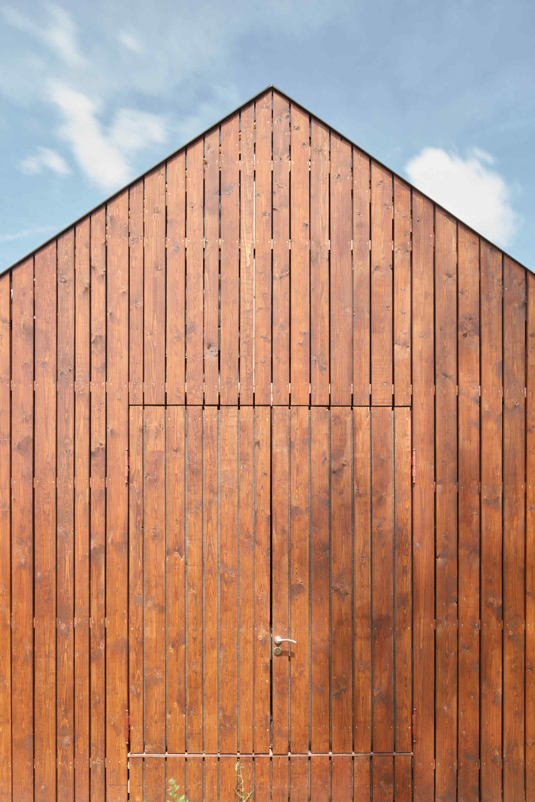 El diseño inteligente de la cabina está inspirado en las tradicionales cabañas de pescadores, integrando los interiores con vistas al estanque y un entorno de roble iluminado por el sol.