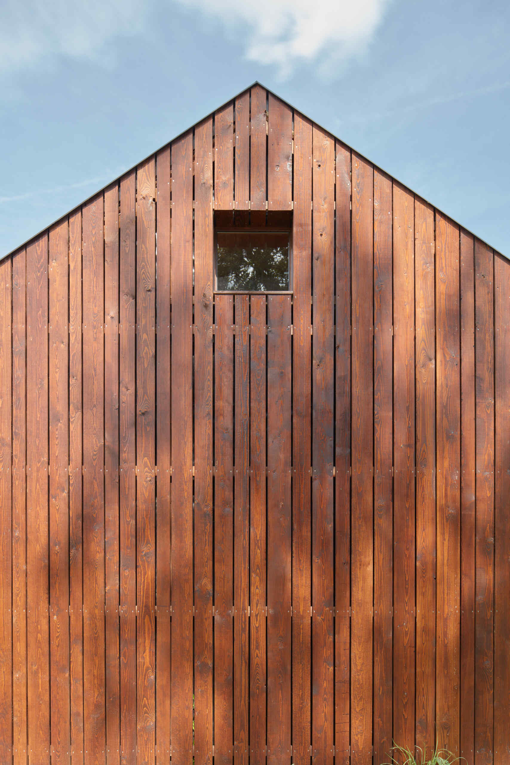 El diseño inteligente de la cabina está inspirado en las tradicionales cabañas de pescadores, integrando los interiores con vistas al estanque y un entorno de roble iluminado por el sol.