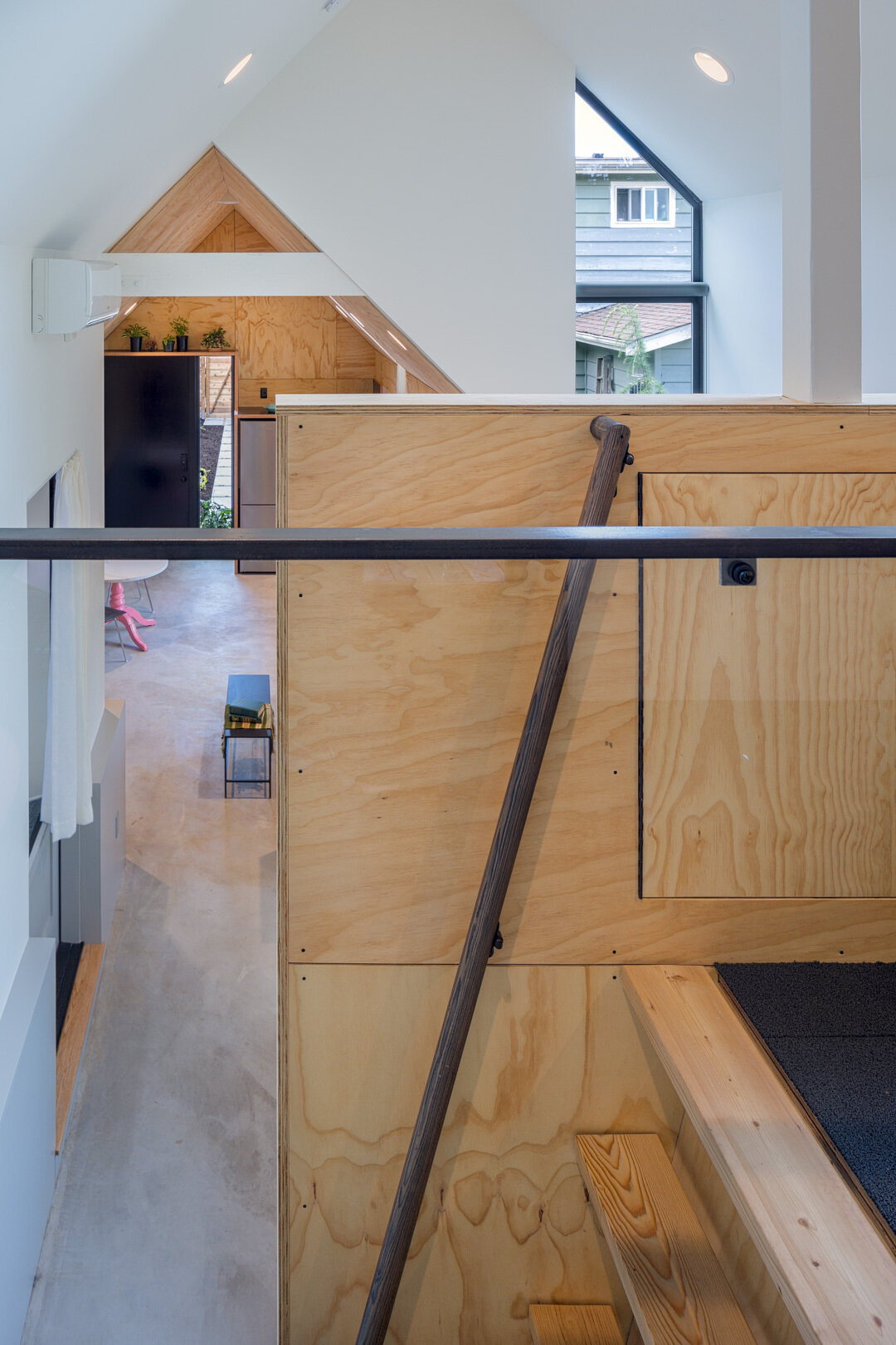 El loft flexible al que se accede por una escalera ofrece ahora espacio de almacenamiento y tiene la opción de convertirse más adelante en una oficina o un área para dormir.