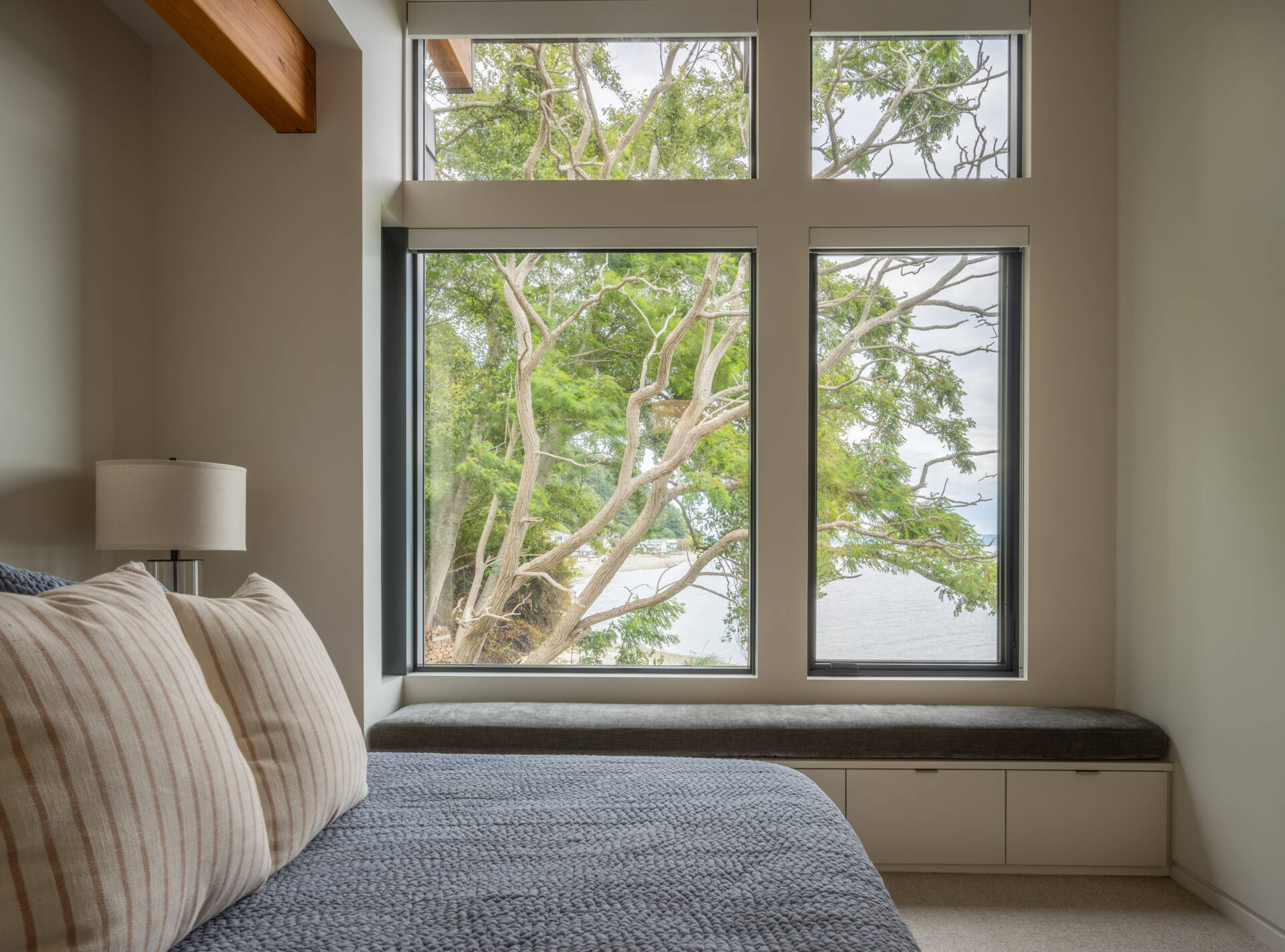 Bedrooms in a modern house have windows that look out to the water.