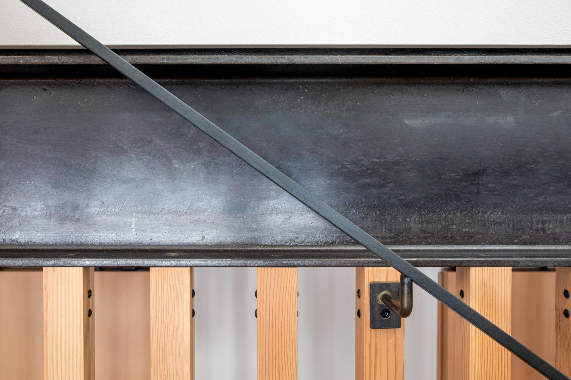 A sculptural stairway with black steel treads and a vertical wood slat screen, allowing light to move freely while adding texture and architectural interest.