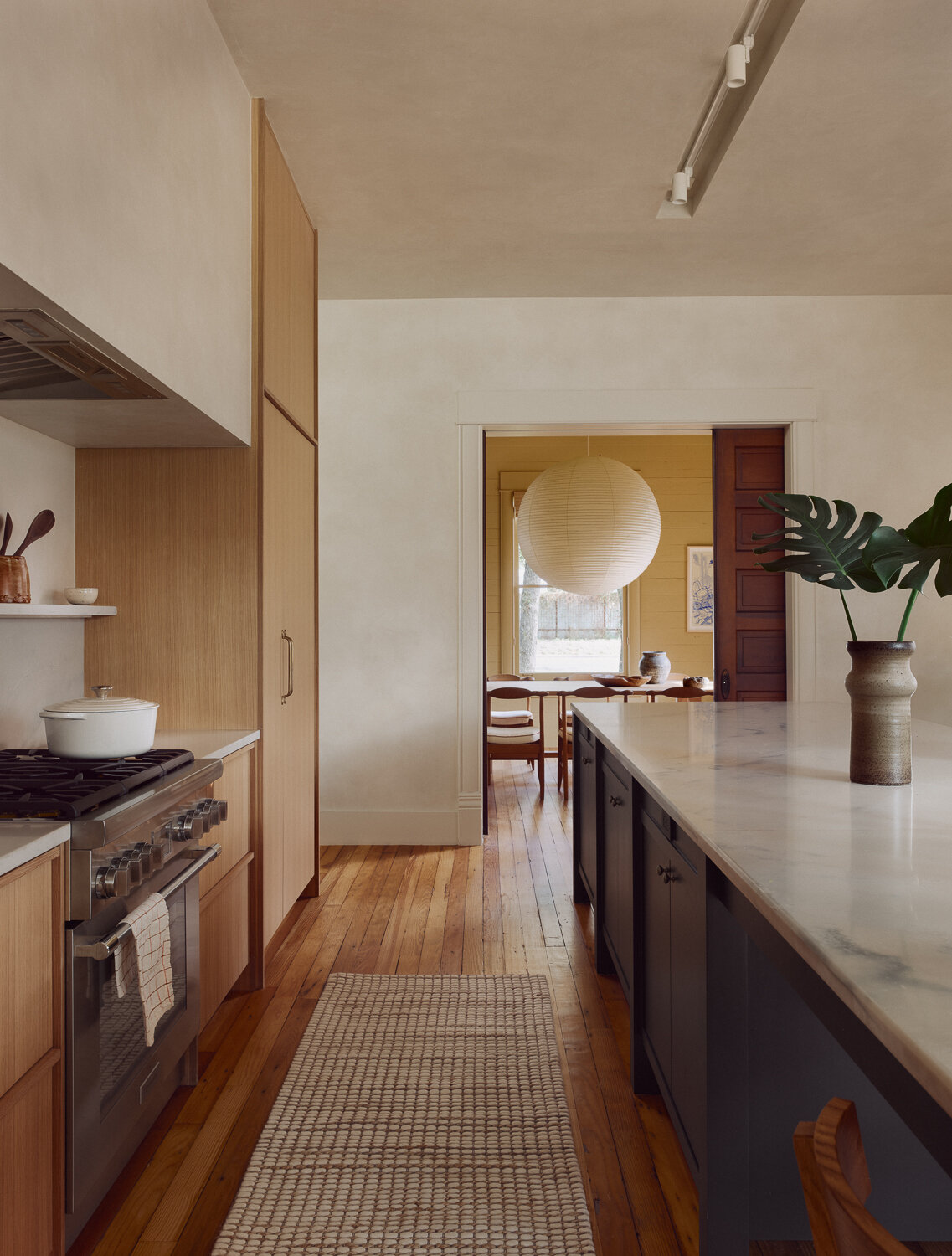The kitchen features Calacatta Ibiza Quartzite countertops paired with custom cabinetry in rift sawn white oak. Integrated pulls keep the design clean and understated, and the material choices align with the broader design focus on natural light, warmth, and timeless finishes.