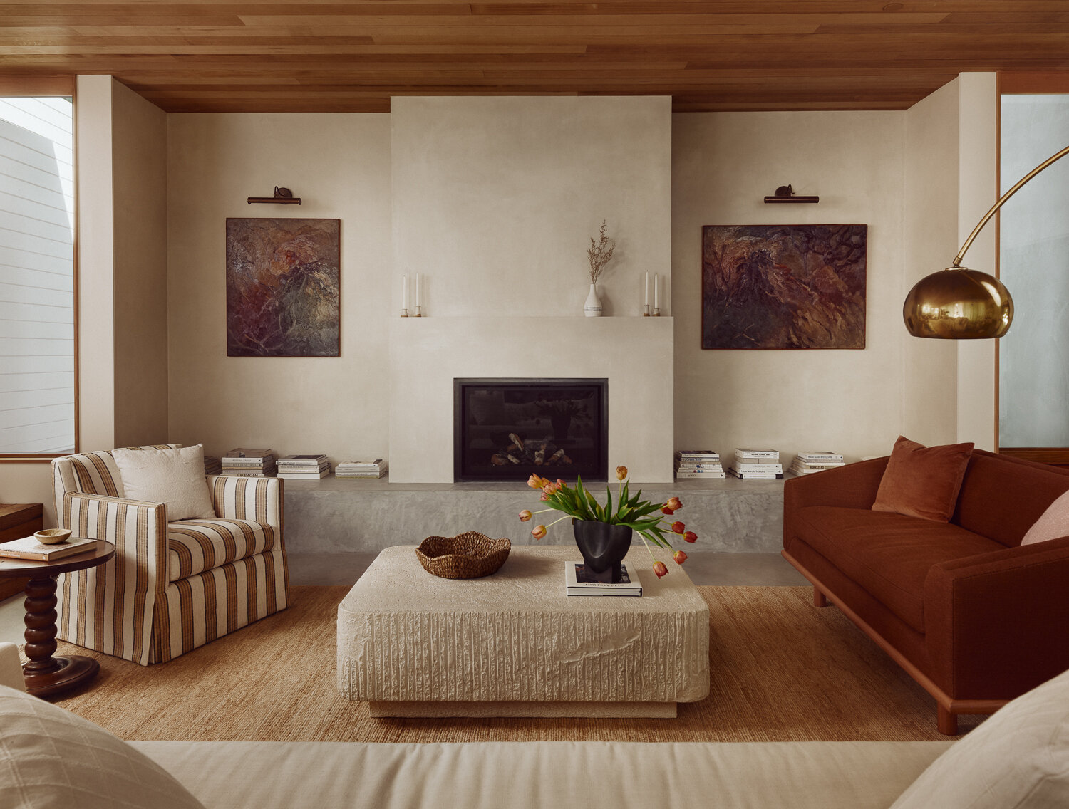 The living room is located within the new addition and introduces a more contemporary feel. Concrete floors define the space, paired with a hemlock wood ceiling above.

A plaster fireplace wall serves as a focal point, finished with elevated plinth seating. Vintage furnishings passed down from Holly Beth Potter’s grandparents bring personal history into the room.