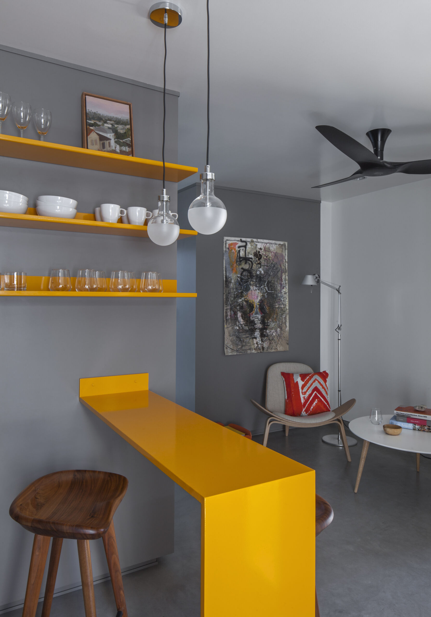 A bold powder coated metal bar adds color and function to this tiny Venice apartment, doubling as dining and prep space without overwhelming the room.