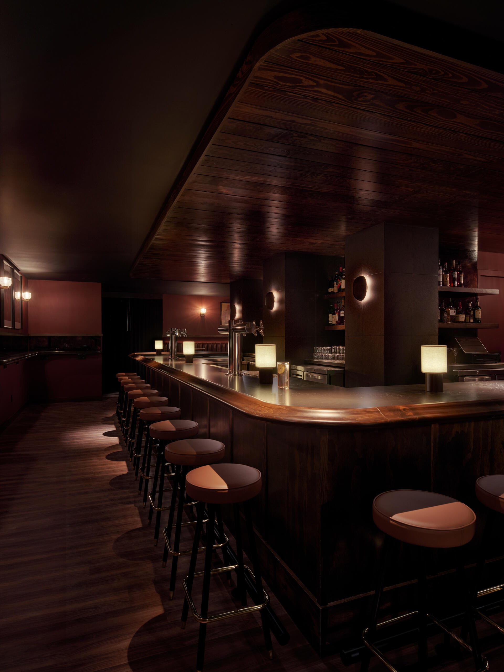 Hot Eye is a basement cocktail bar with dark terrazzo, deep wood tones, red accents, and a cozy neighborhood feel.