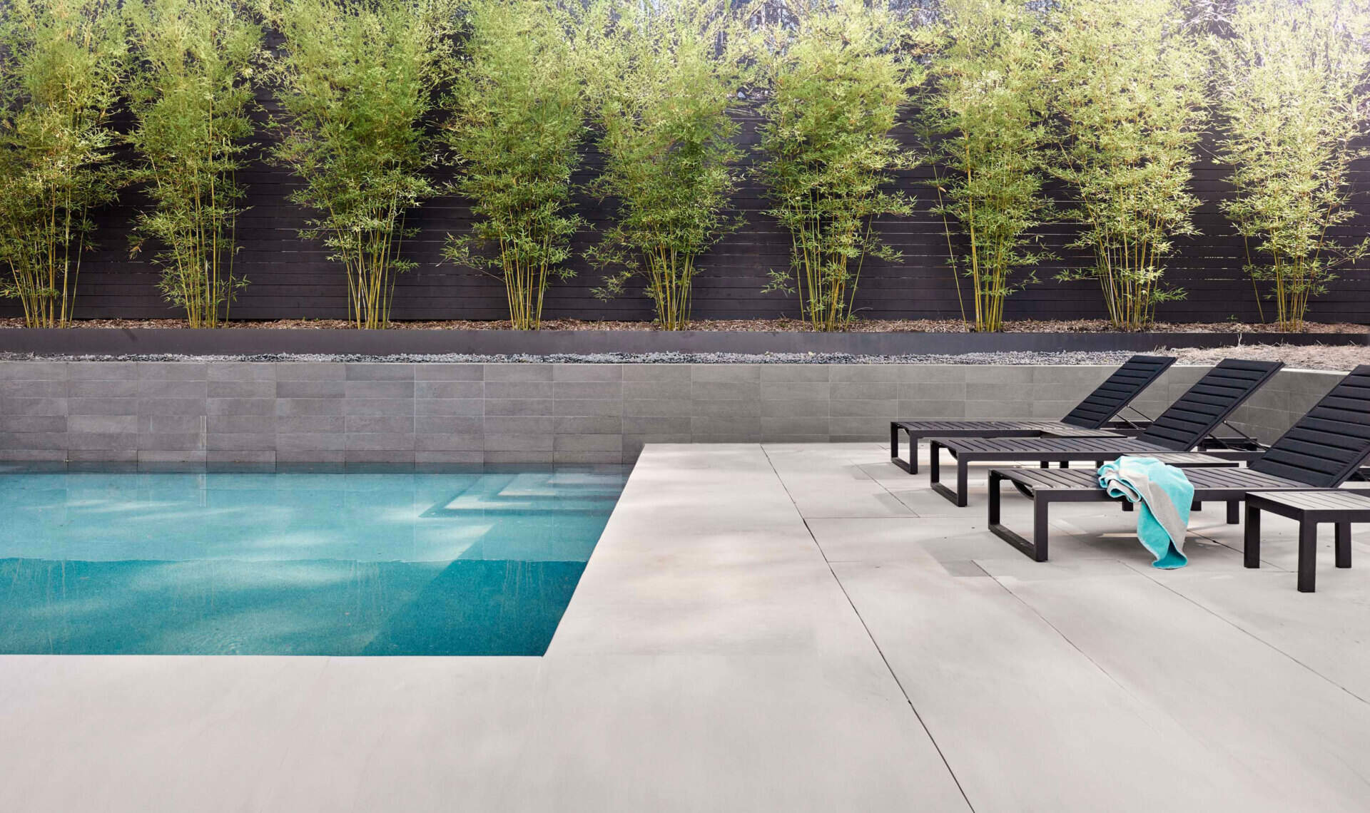 El patio trasero de varios niveles cuenta con una piscina y una cancha de bochas, lo que amplía el espacio habitable al aire libre.