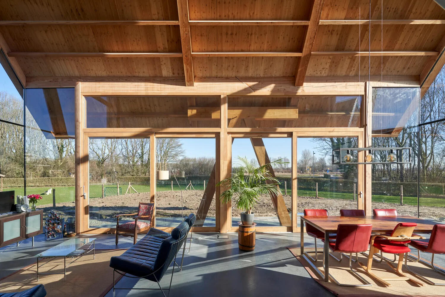 A soaring gable roof and floor-to-ceiling windows flood the open plan living and dining area with natural light from three sides.