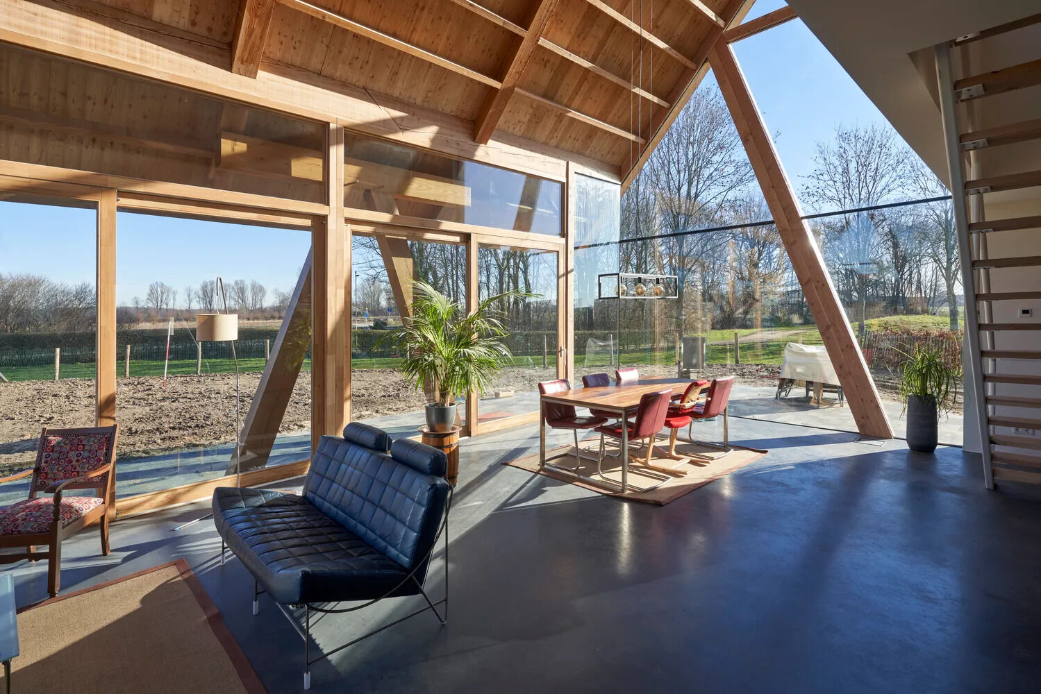A soaring gable roof and floor-to-ceiling windows flood the open plan living and dining area with natural light from three sides.