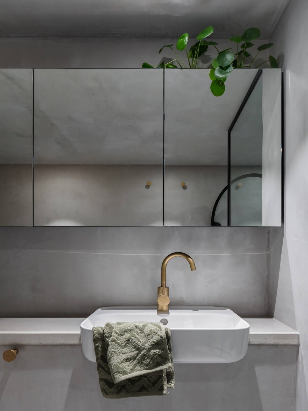 Una elegante cabina de ducha con vidrio enmarcado en negro agrega una sensación distintivamente moderna a este baño.