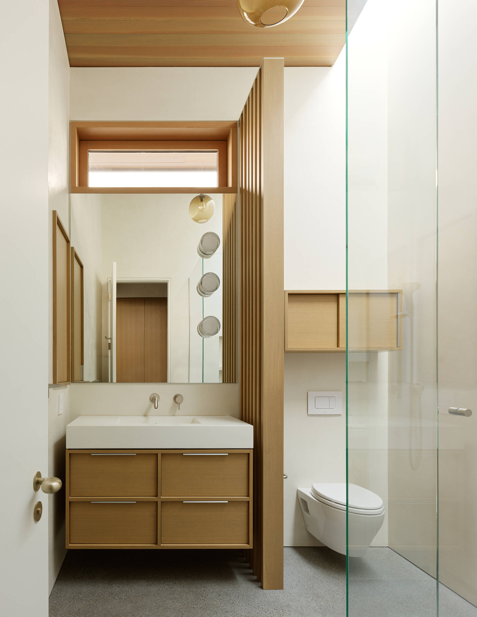 Private spaces maintain the home’s light and natural material palette. Large windows and simple finishes create calm, welcoming bedrooms and bathrooms, ensuring a consistent sense of openness.