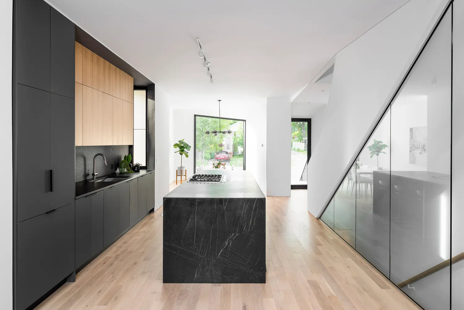 Matte black kitchen cabinets and island take centre stage inside a calm white interior, adding depth and drama without overwhelming the space.